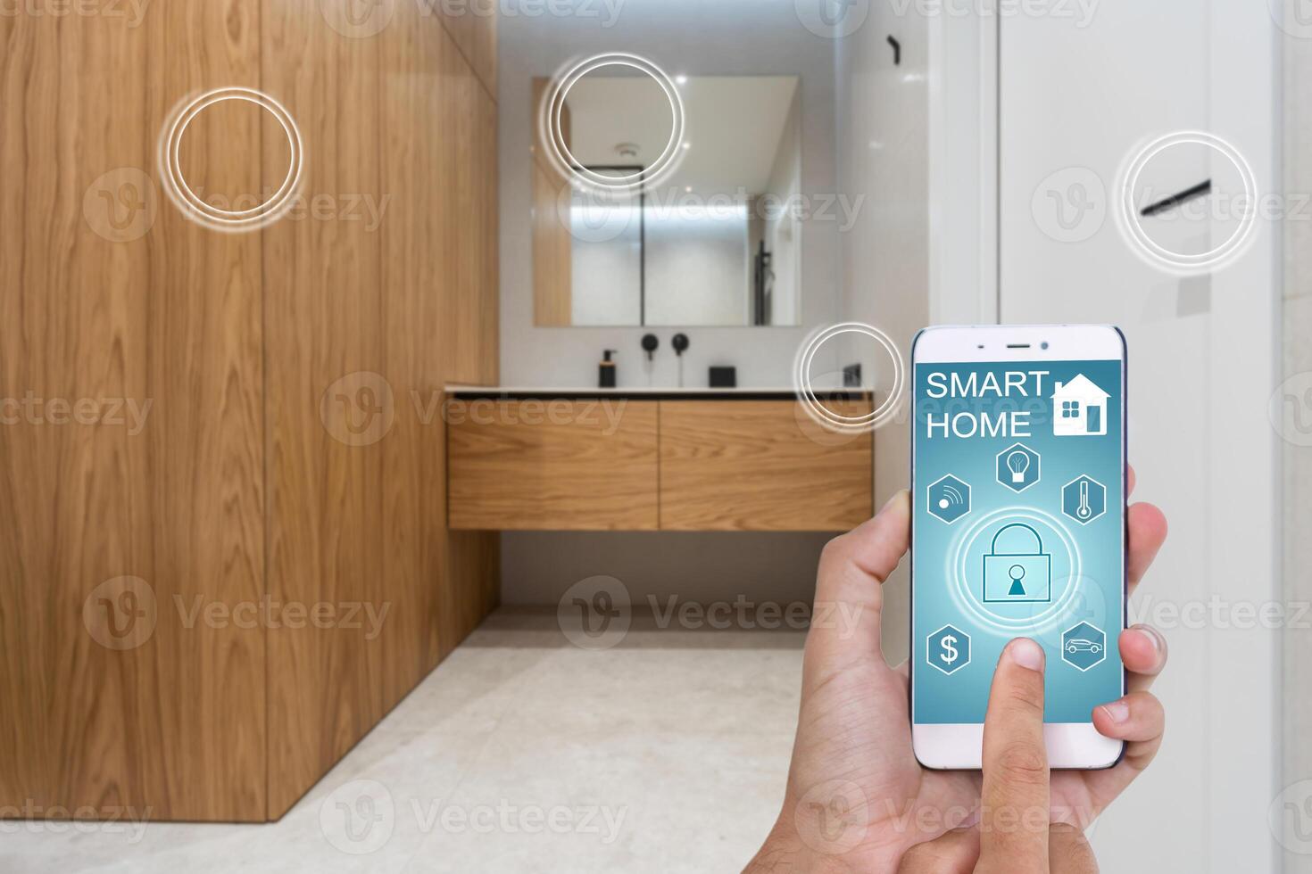 Young woman holding smart phone with launched security application at home. Concept of controlling and managing home security from a mobile device photo