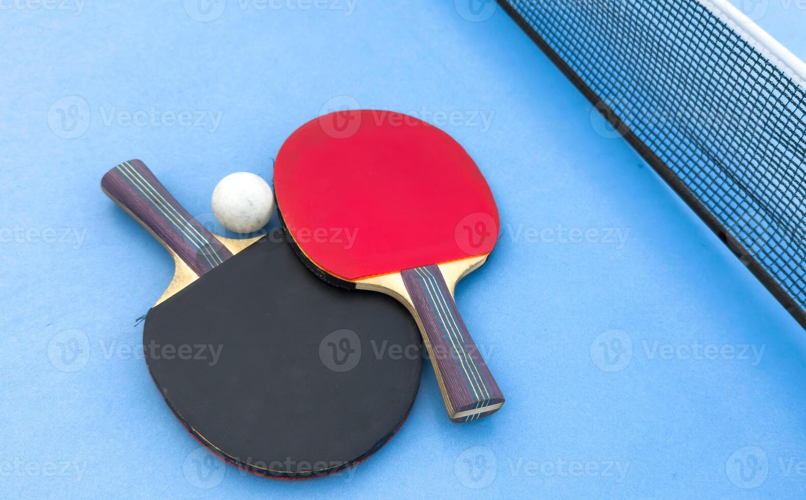 table tennis or ping pong racket and balls on a blue table photo
