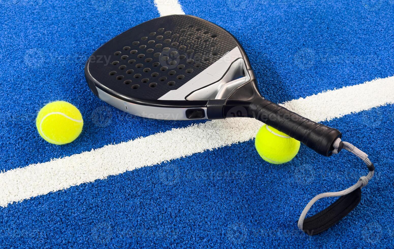 Black professional paddle tennis racket and ball on blue background. Horizontal sport theme poster, greeting cards, headers, website and app photo