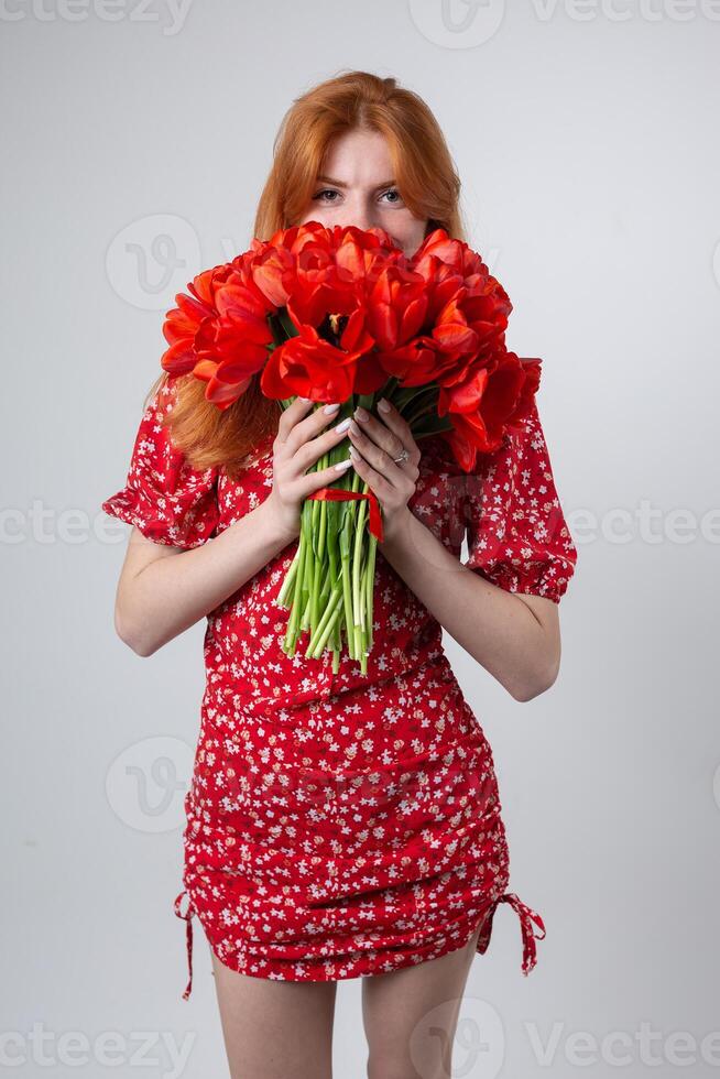 Young happy woman with a bouquet of red lulips. photo