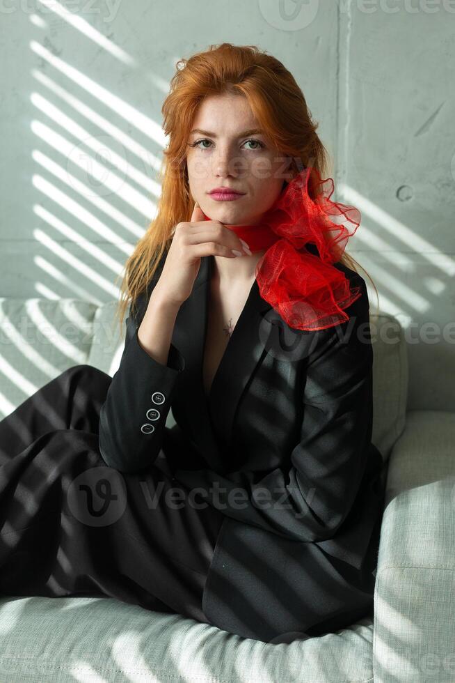 Portrait of a red-haired girl with a red scarf around her neck photo