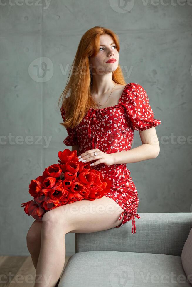 Young happy woman with a bouquet of red lulips. photo