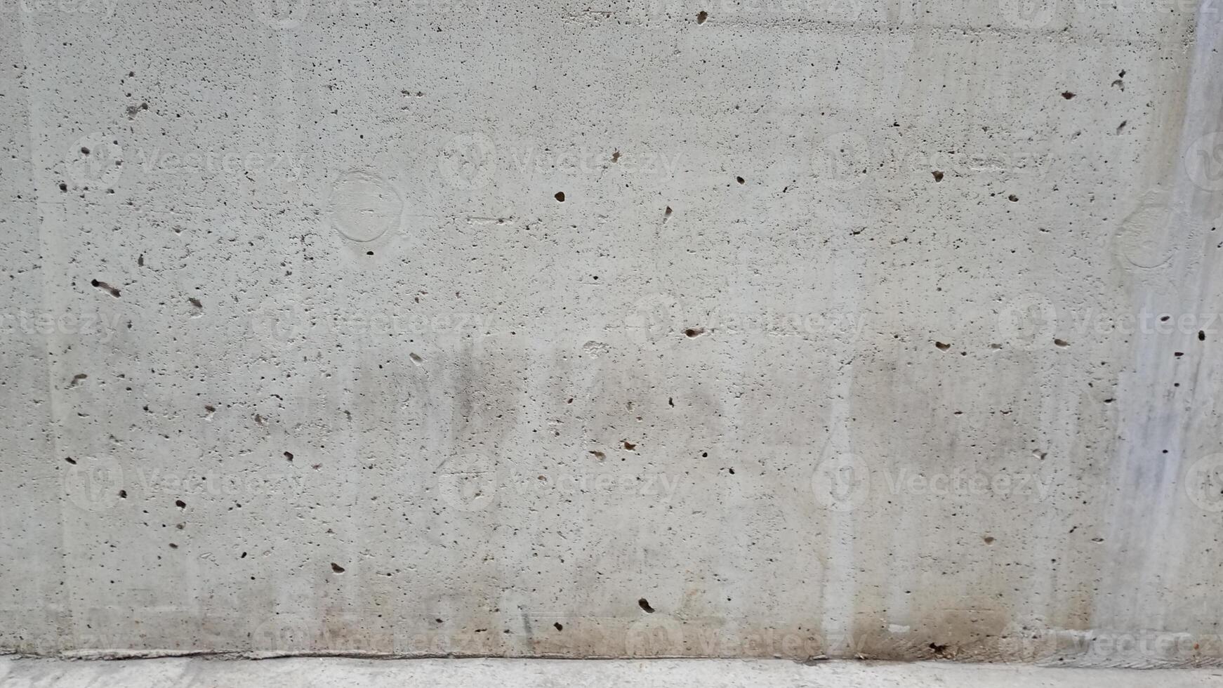 Close up of a weathered concrete surface with visible pores and grains. Ideal for industrial or rustic designs photo