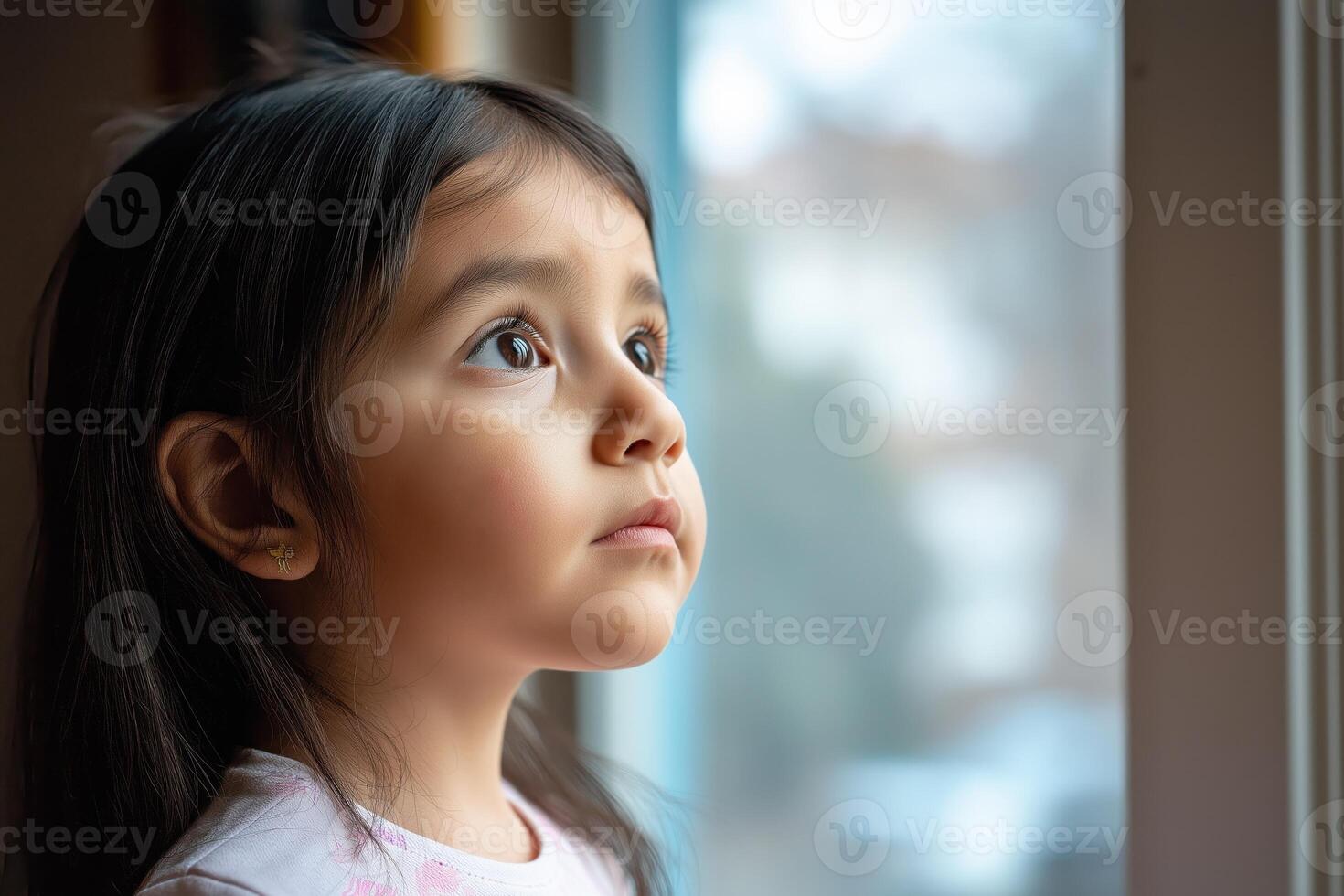 Thoughtful Latin girl looking out window photo