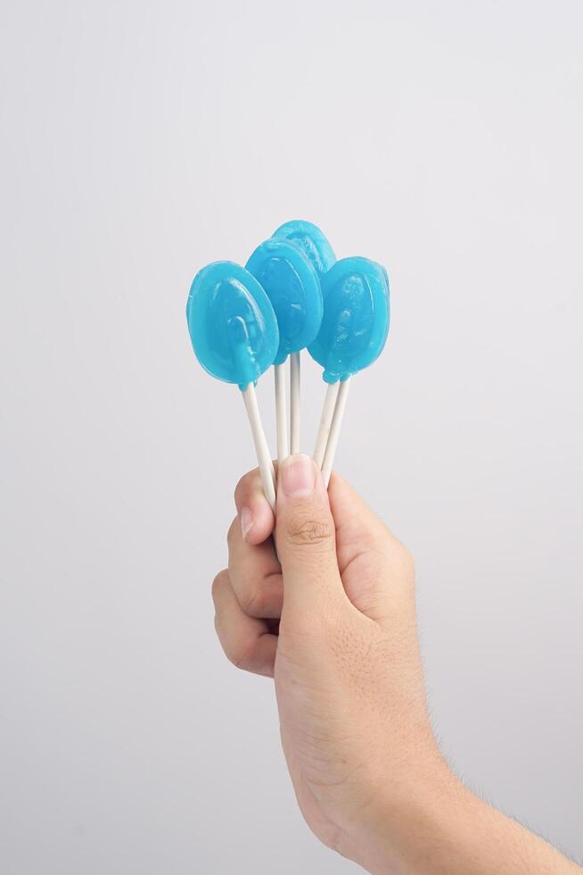 Hand holding blue lollipop isolated on white background. high resoluton photo. photo