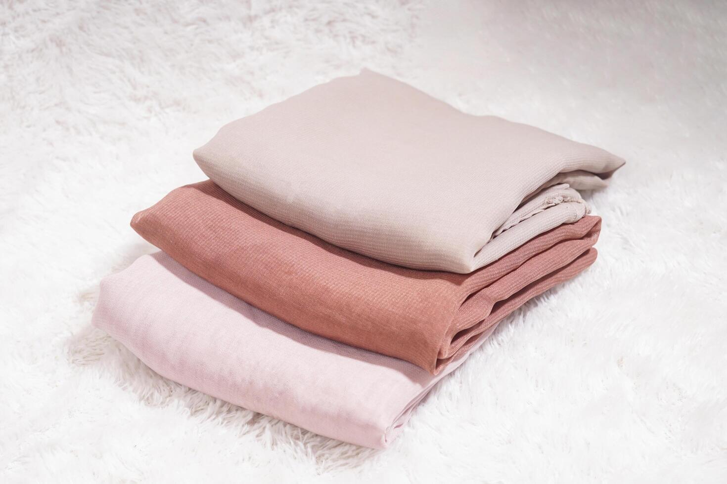 Hijab pile in soft colors, isolated on a white background. Hijab mockup with high-resolution photos