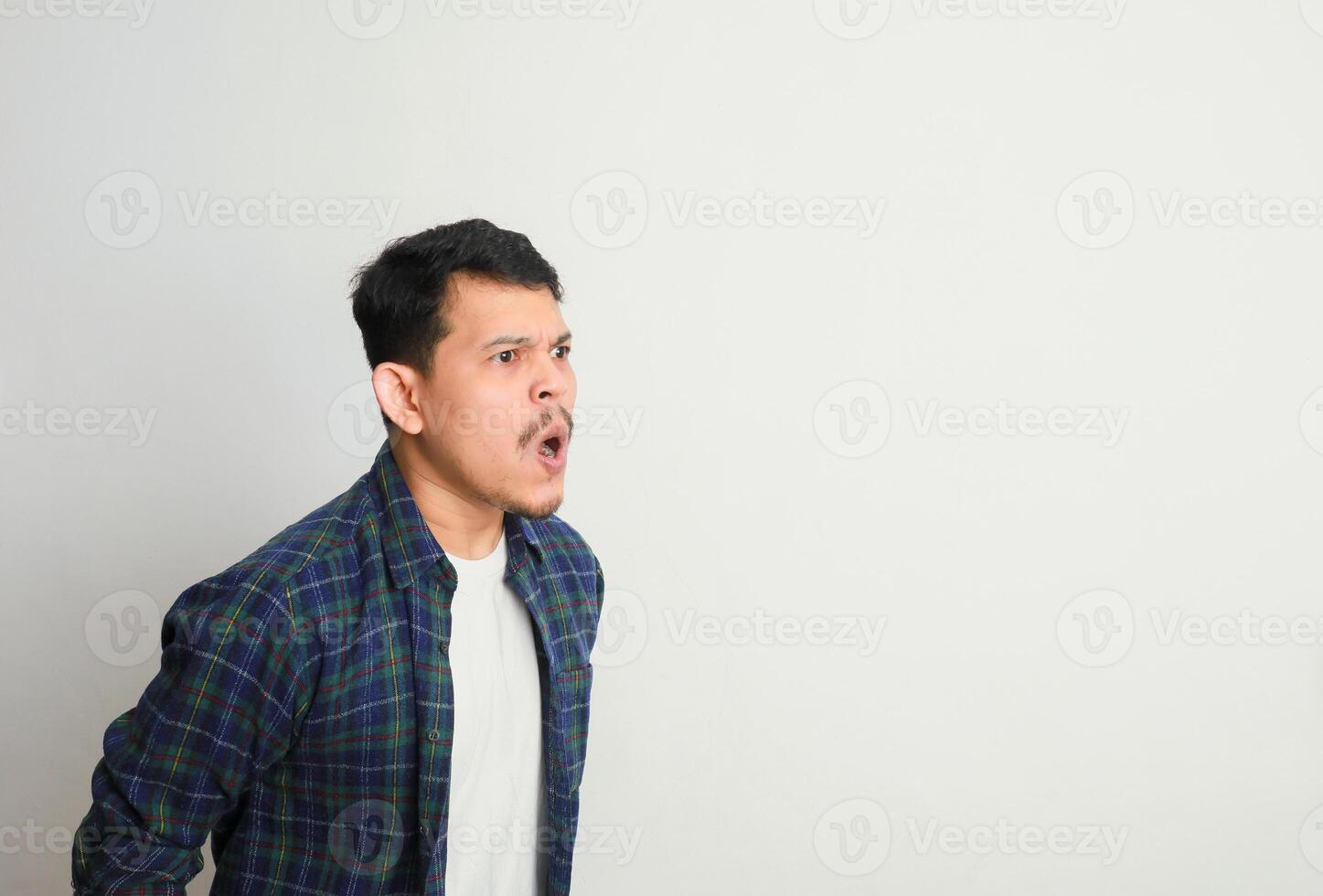 side view of young asian man with angry expression and shouting photo