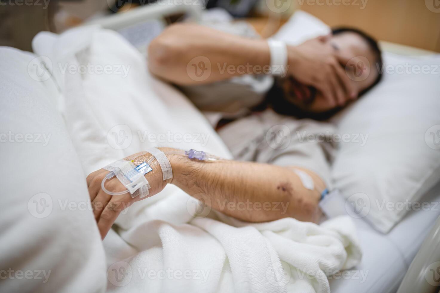 Middle Aged Man Resting Alone in a Hospital Room, Receiving IV Fluids and Medical Care photo