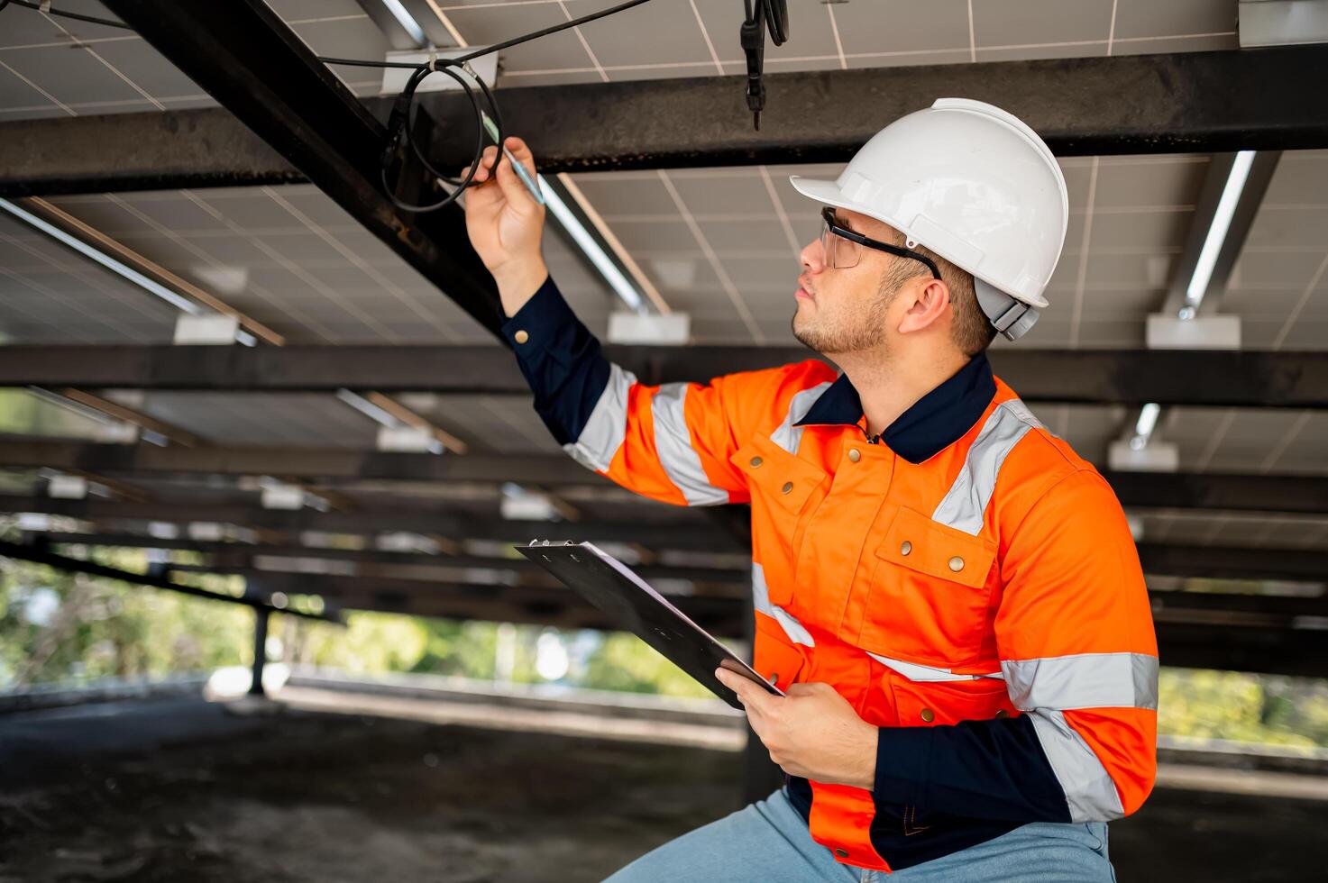 Male maintenance engineer inspects the operation of solar panels and makes repairs. photo