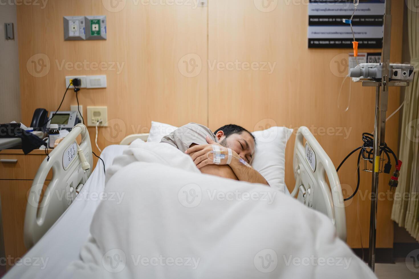 Middle Aged Man Resting Alone in a Hospital Room, Receiving IV Fluids and Medical Care photo