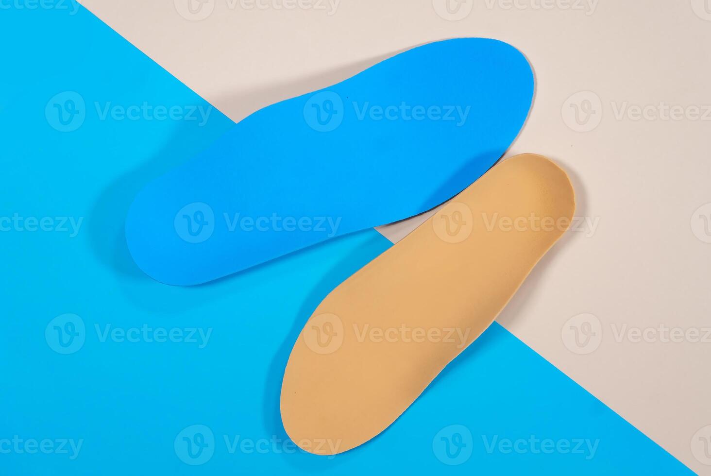 Orthopedic insoles are lined up on a wooden surface. samples of different orthopedic insoles. insoles with a variety of coating. photo