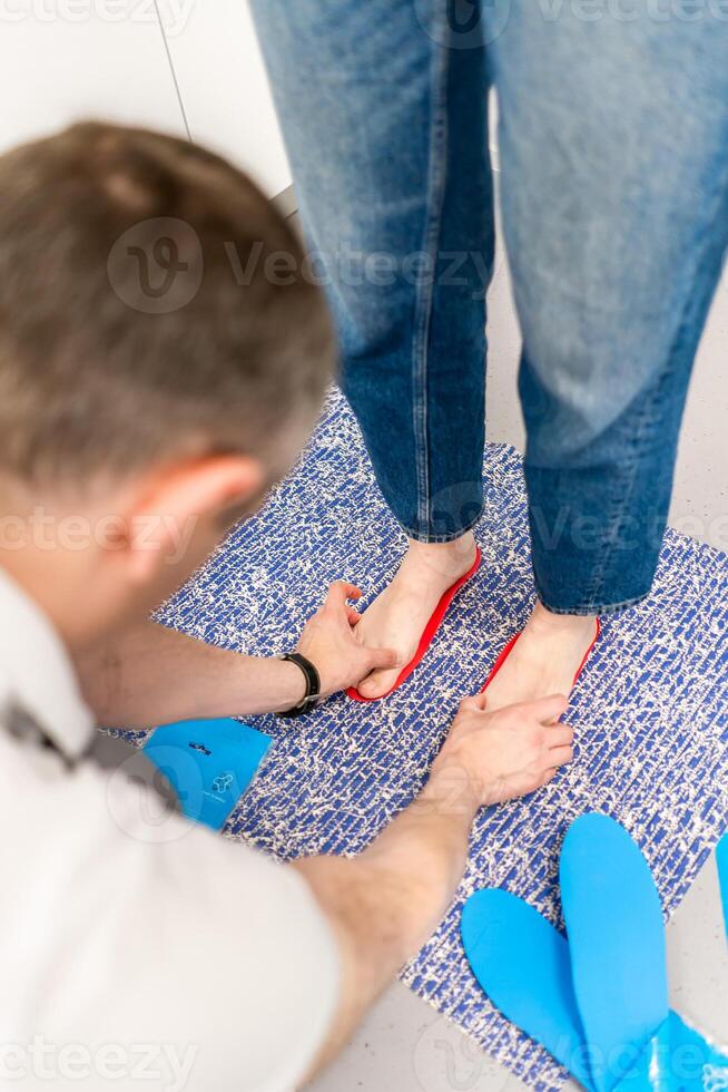 Orthopedic insole. The orthopedist works with the patient. Orthopedic clinic. Choice of insoles in an orthopedic clinic. The orthopedist offers the insole to the patient Foot care photo