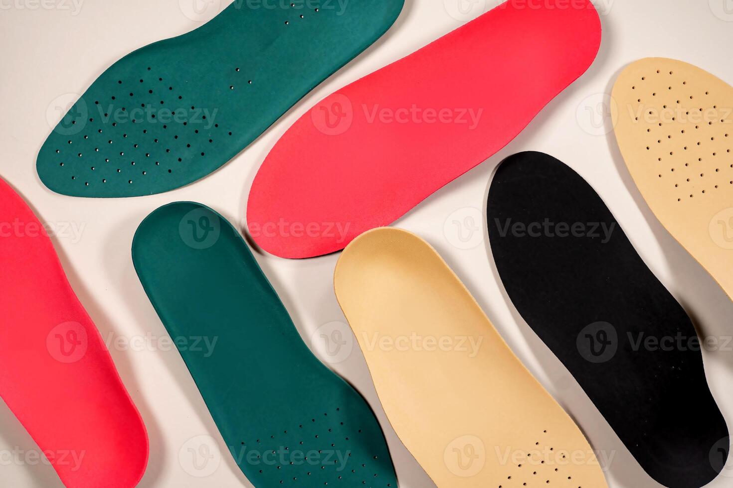 Orthopedic insoles are lined up on a wooden surface. samples of different orthopedic insoles. insoles with a variety of coating. photo
