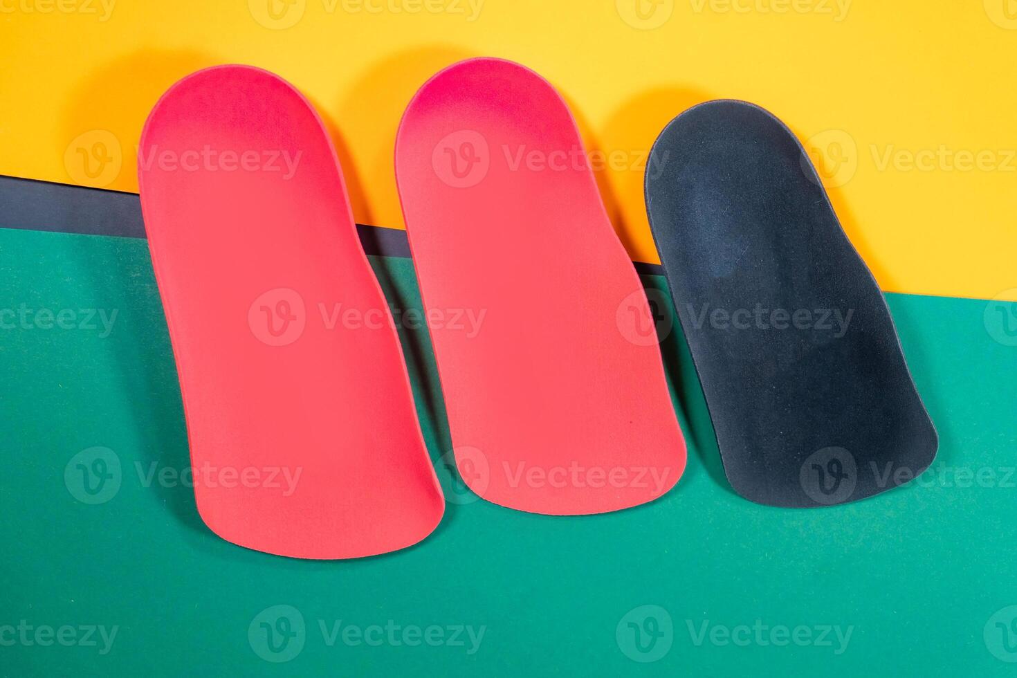 Orthopedic insoles are lined up on a wooden surface. samples of different orthopedic insoles. insoles with a variety of coating. photo