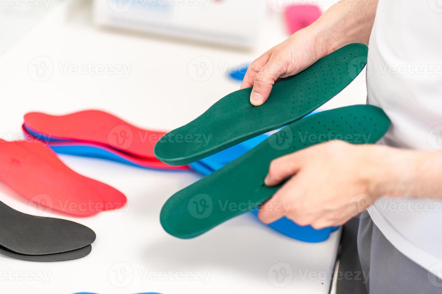 Orthopedic insole. The orthopedist works with the patient. Orthopedic clinic. Choice of insoles in an orthopedic clinic. The orthopedist offers the insole to the patient Foot care photo