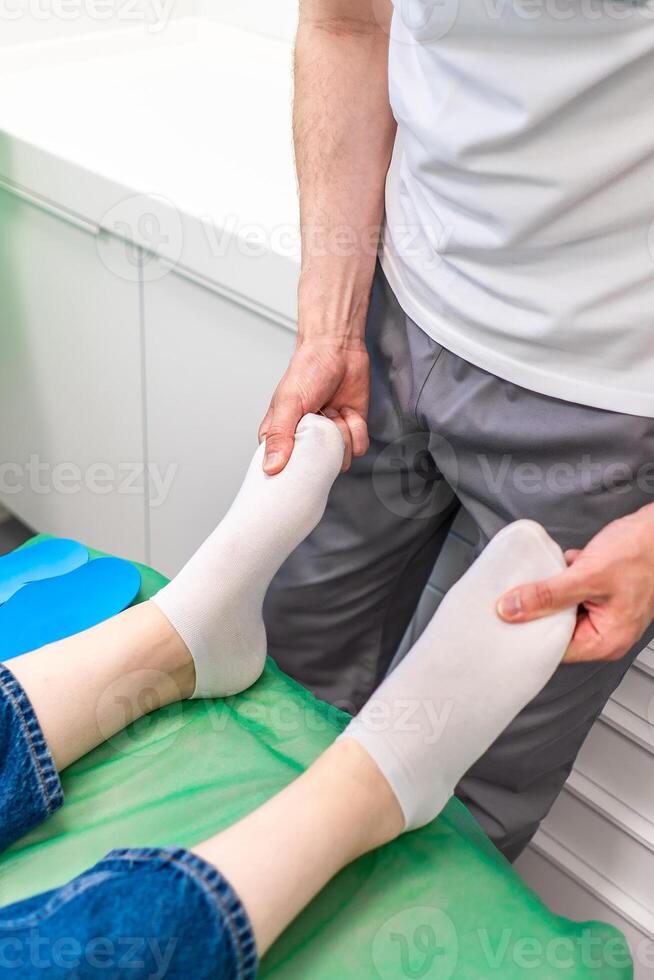 Orthopedic insole. The orthopedist works with the patient. Orthopedic clinic. Choice of insoles in an orthopedic clinic. The orthopedist offers the insole to the patient Foot care photo