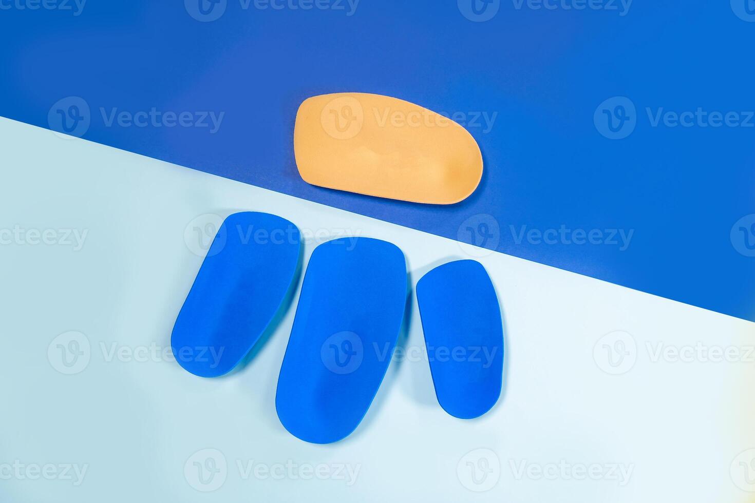 Foot support and healthy feet concept with orthopedic shoe insoles isolated on color background photo