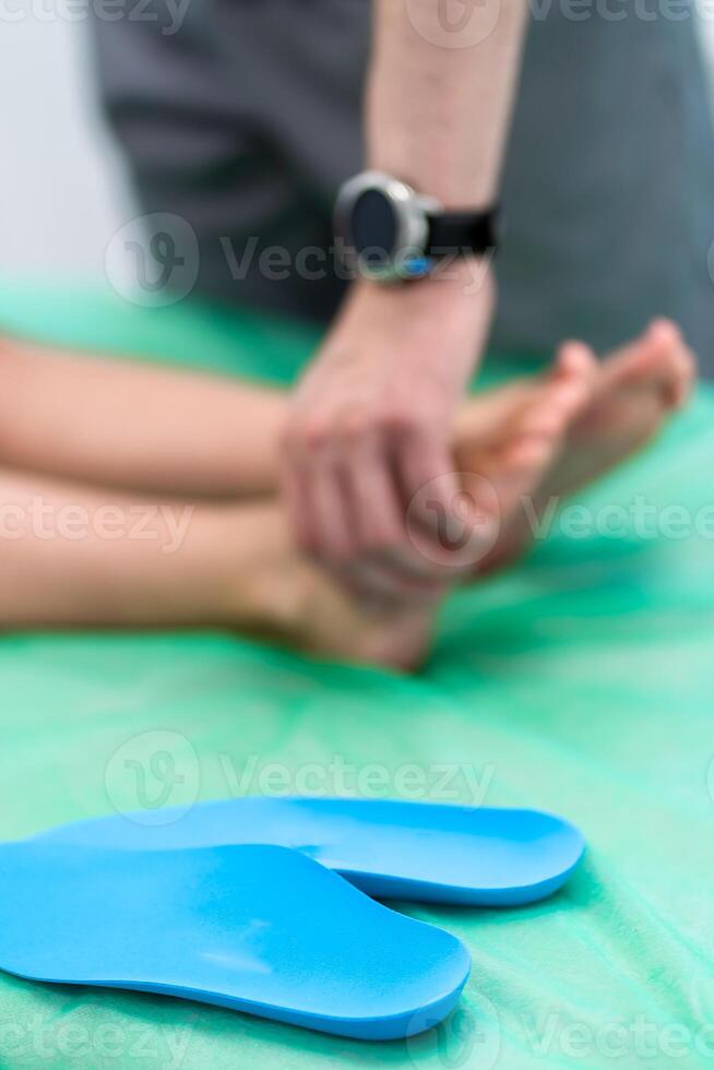 Orthopedic insole. The orthopedist works with the patient. Orthopedic clinic. Choice of insoles in an orthopedic clinic. The orthopedist offers the insole to the patient Foot care photo