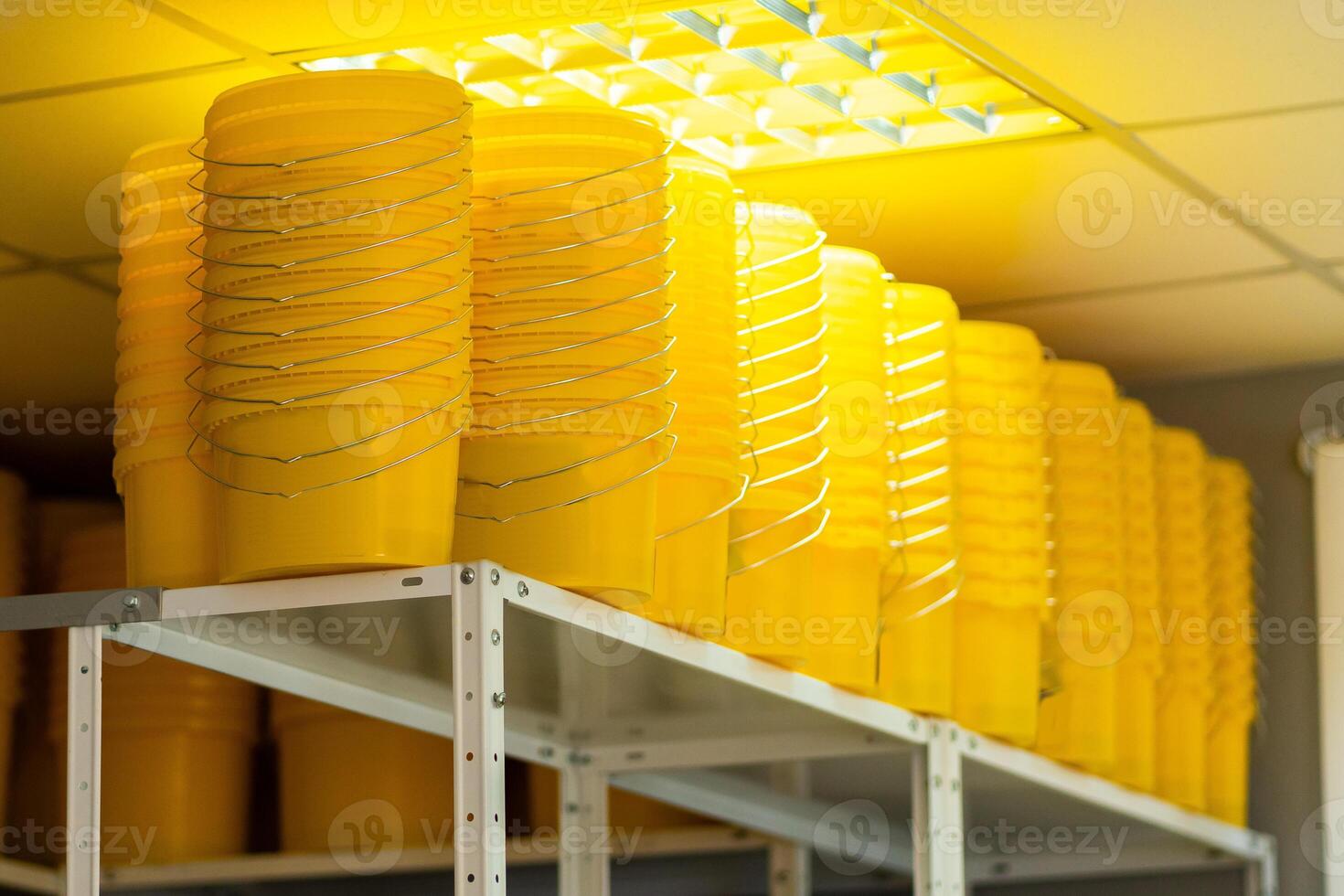 Many yellow color buckets cans in a row with ink paint row photo