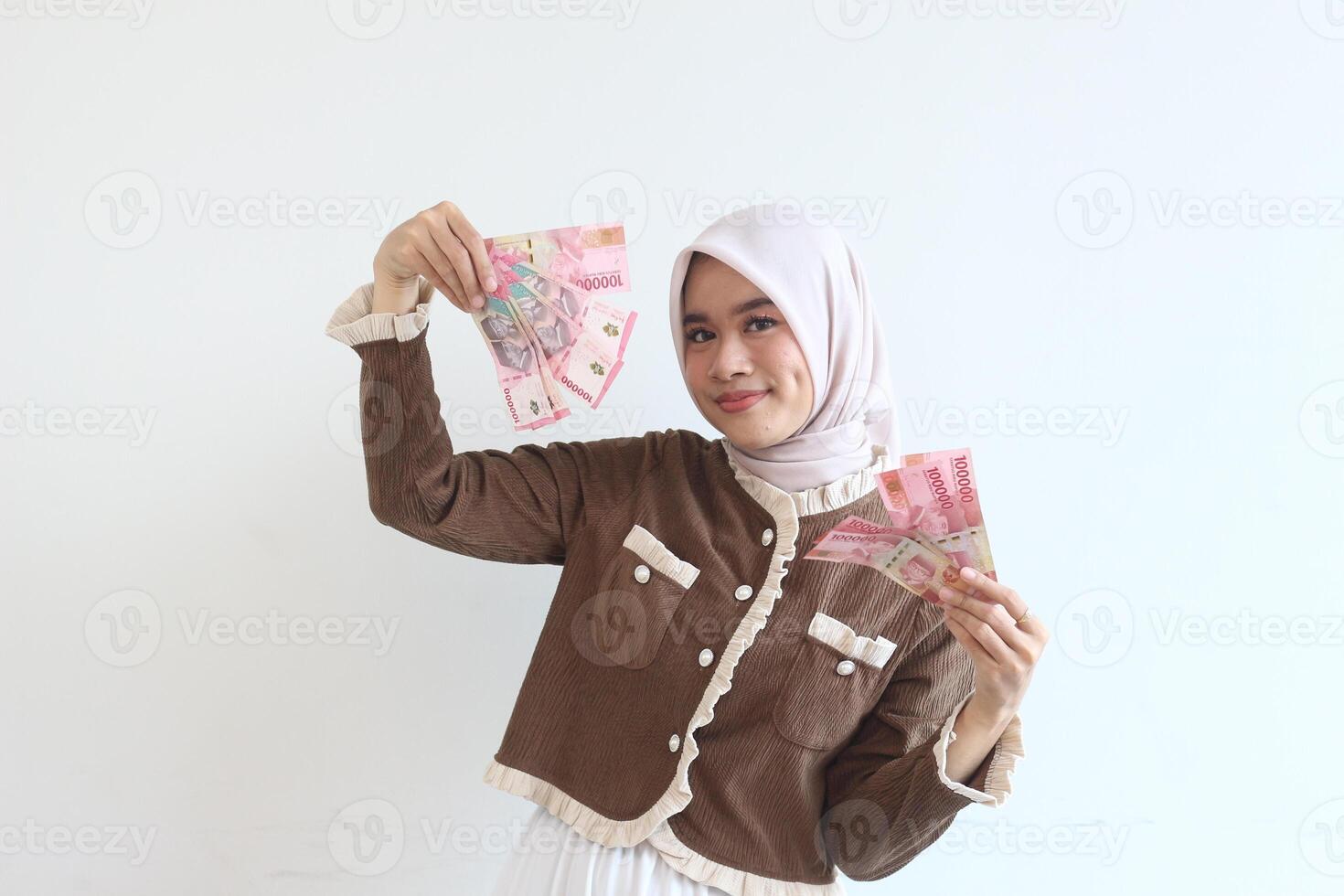 Smiling Woman in Hijab Holding Indonesian Rupiah Banknotes Happy Financial Success Portrait photo