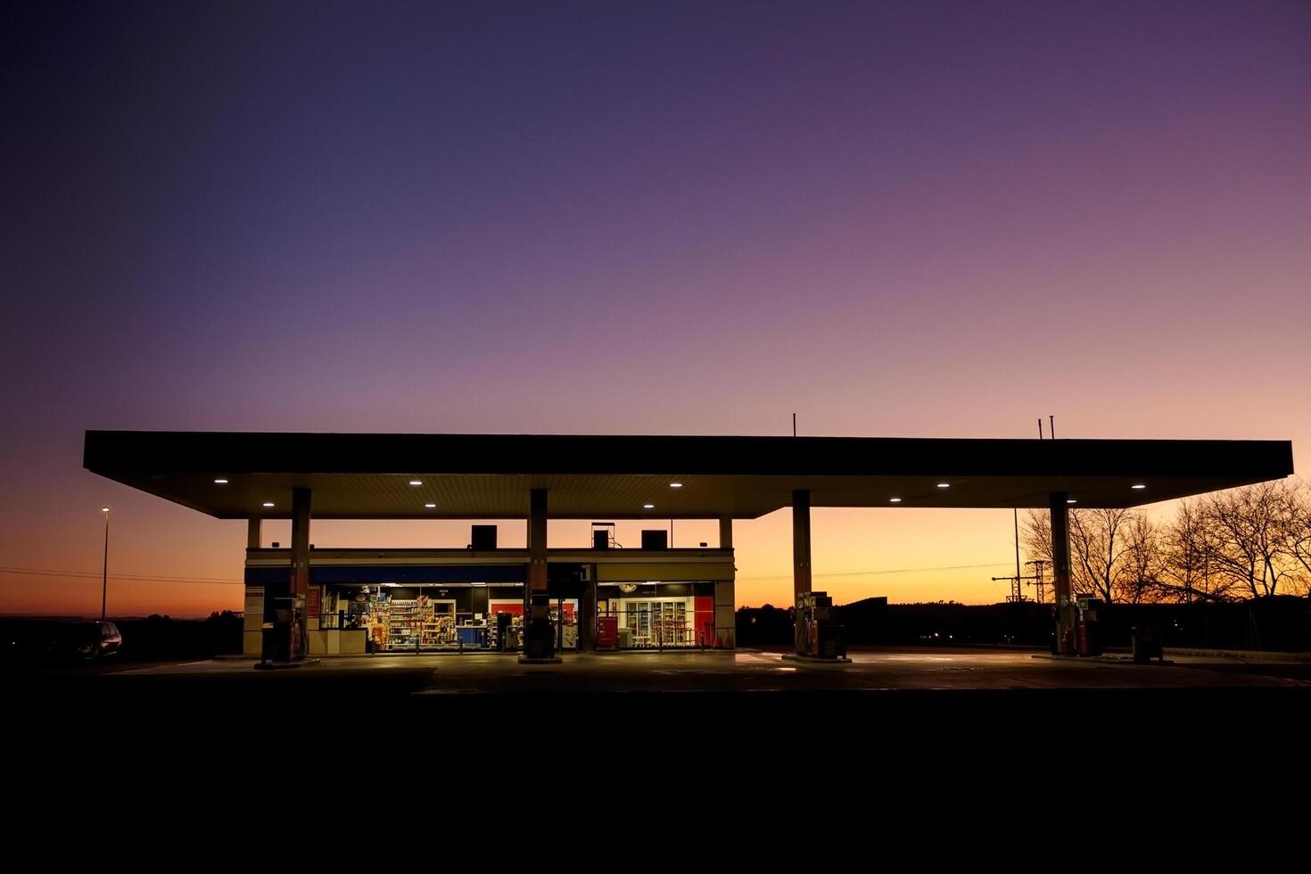 Illuminated gas station under a darkening twilight sky with empty surroundings and no visible vehicles or people photo