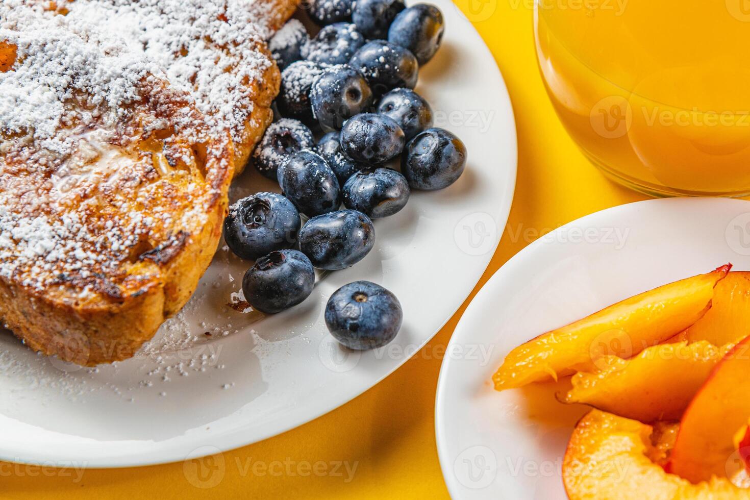 French toast on a plate with blueberries, orange juice, nectarine for breakfast photo