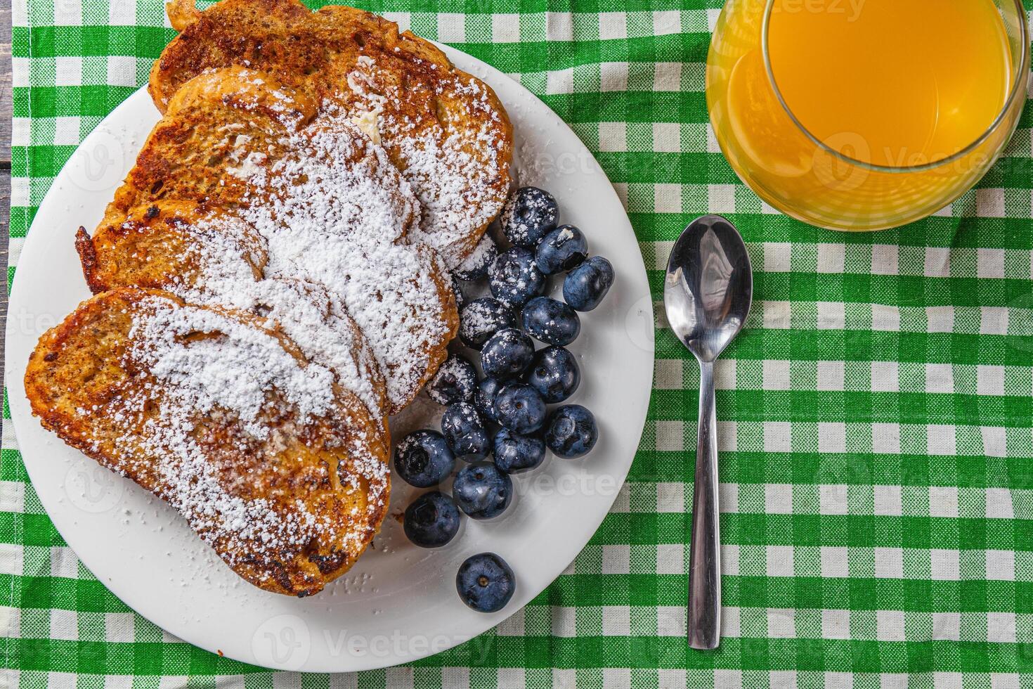 French toast on a white plate with blueberries and orange juice for breakfast photo