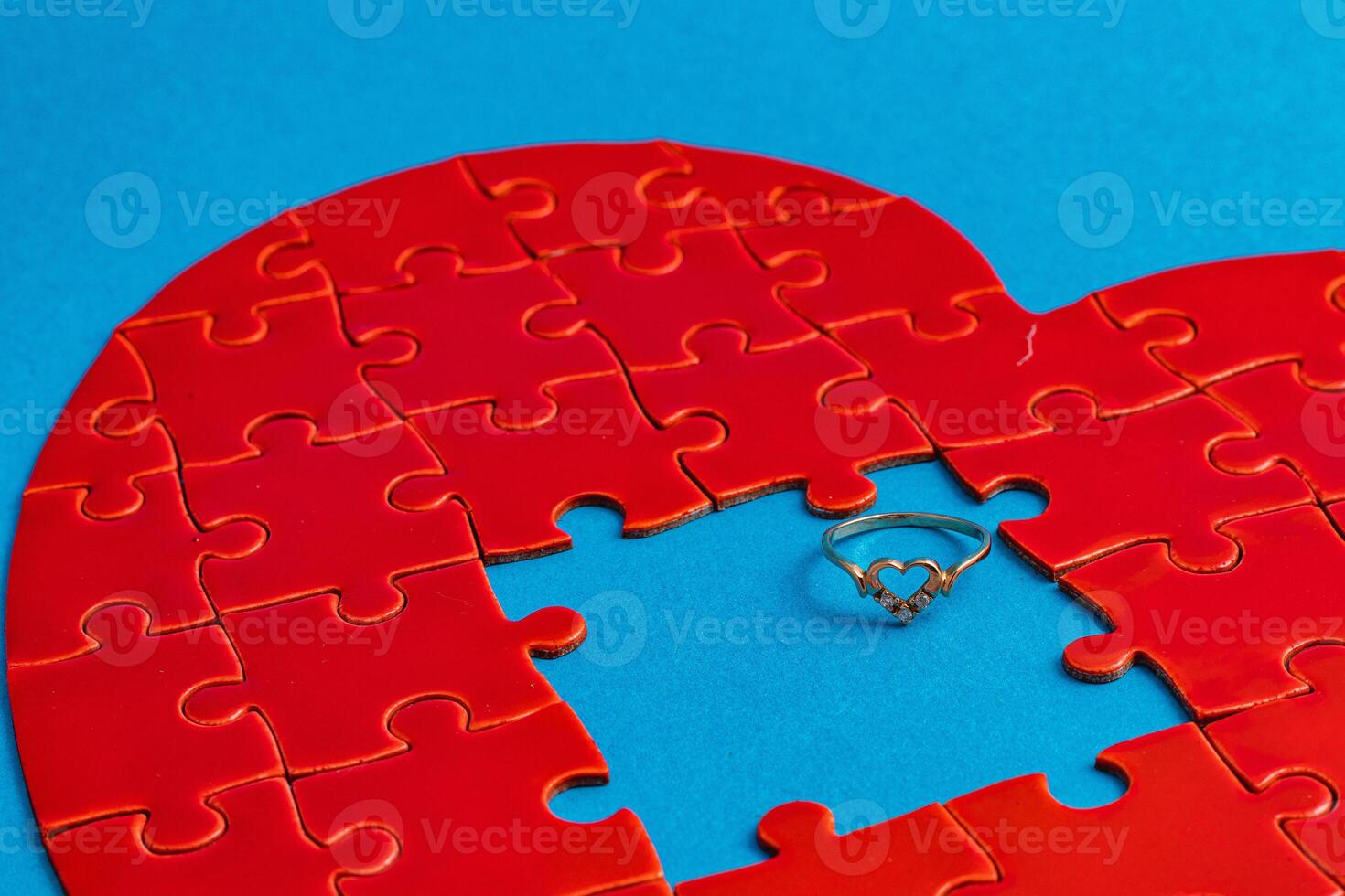 Love concept. Broken heart puzzle with wedding ring, missing puzzle pieces photo