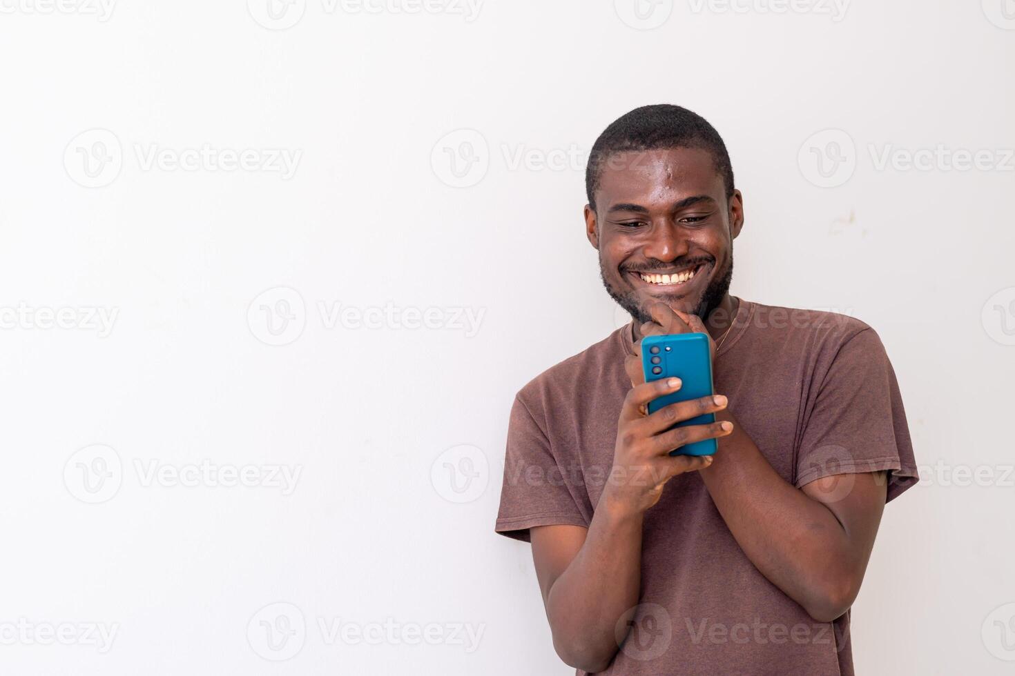 black African american guy holding big smartphone with white blank screen in hand, showing close to camera and pointing at the phone. photo