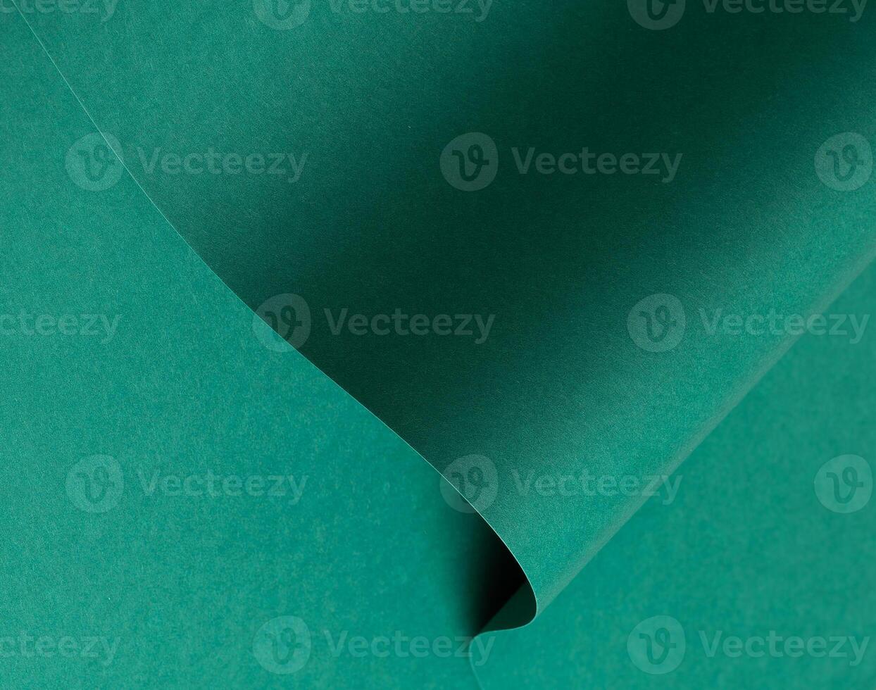 Emerald green paper background with a matte finish and subtle wavy texture. Deep green tones create photo