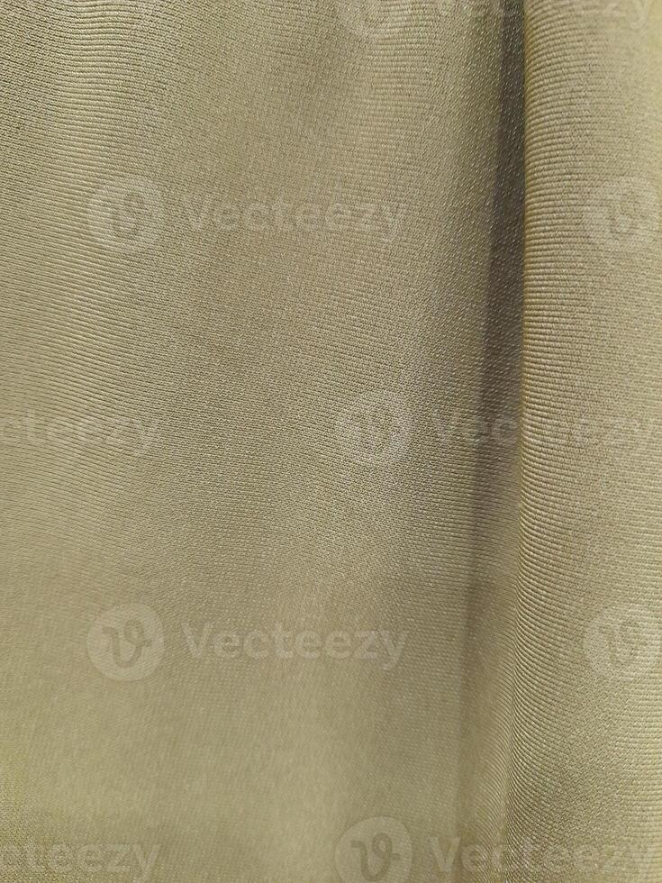 a close-up view of a light-colored fabric surface. The texture appears soft and smooth, with subtle creases and wrinkles running horizontally across the material. photo