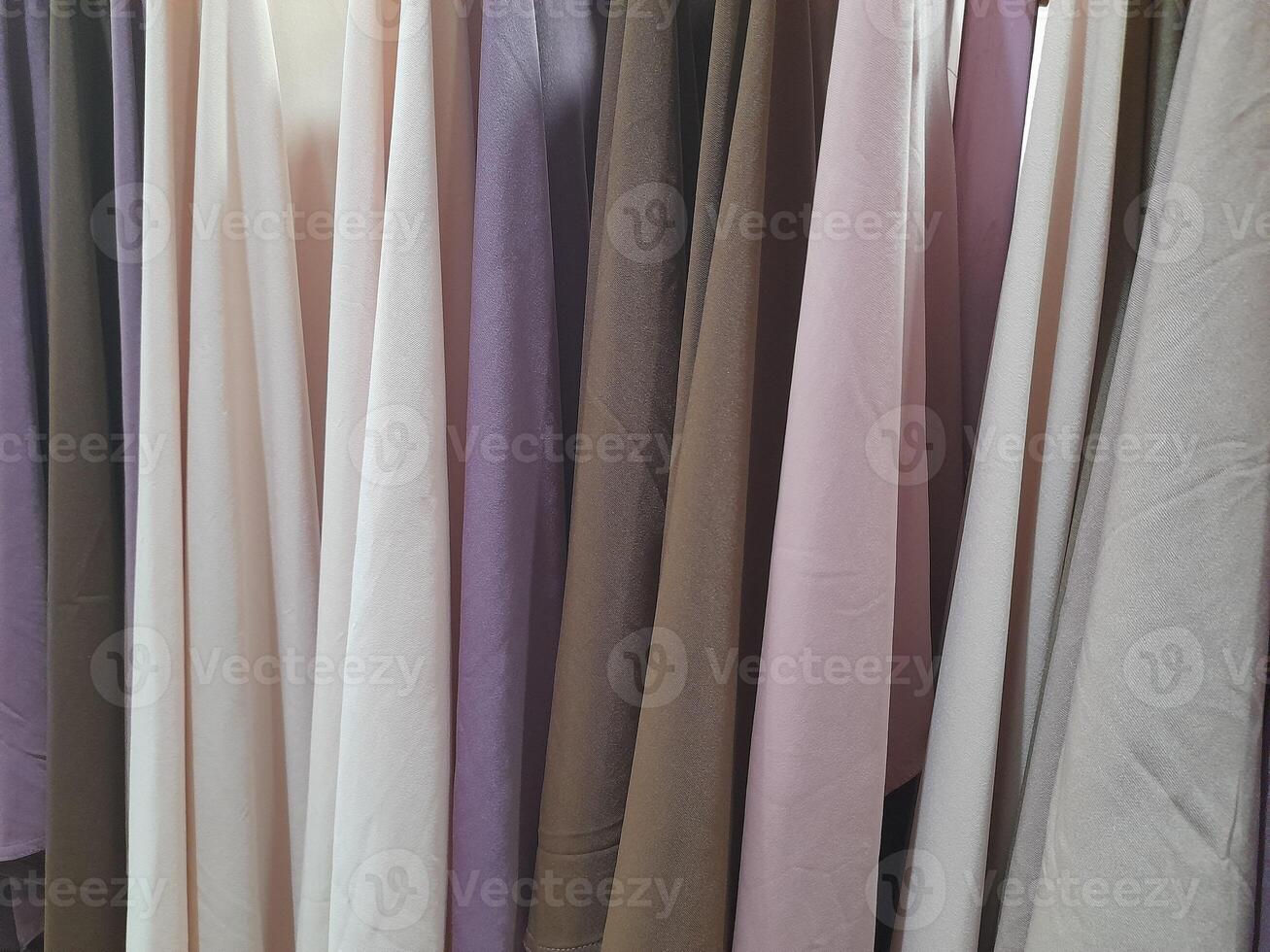 a close-up view of a light-colored fabric surface. The texture appears soft and smooth, with subtle creases and wrinkles running horizontally across the material. photo