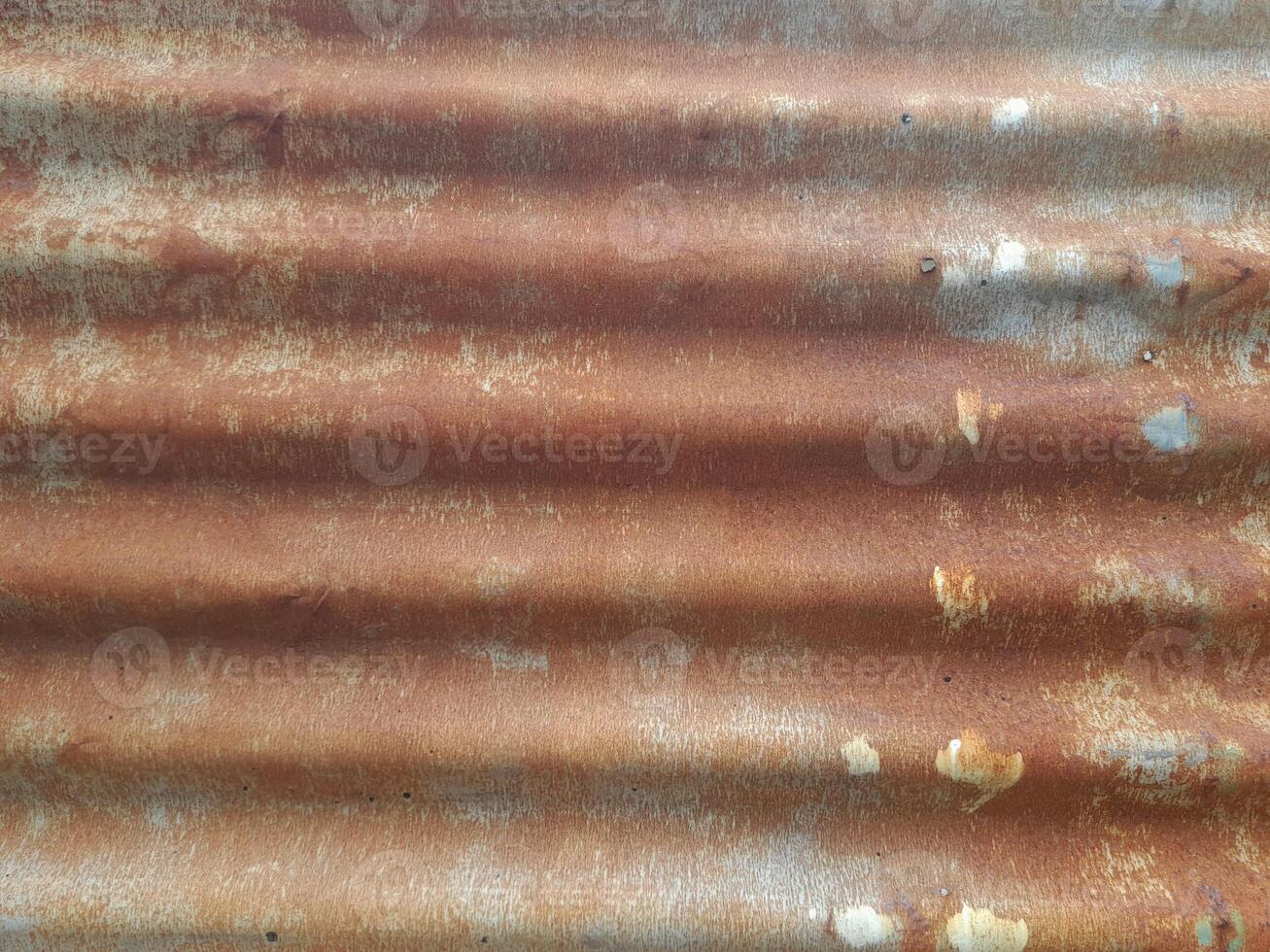 a close-up view of a textured surface a metal sheet, with a dull grayish tone. The surface features a mix of light and dark patches, creating a mottled, weathered, or oxidized appearance photo