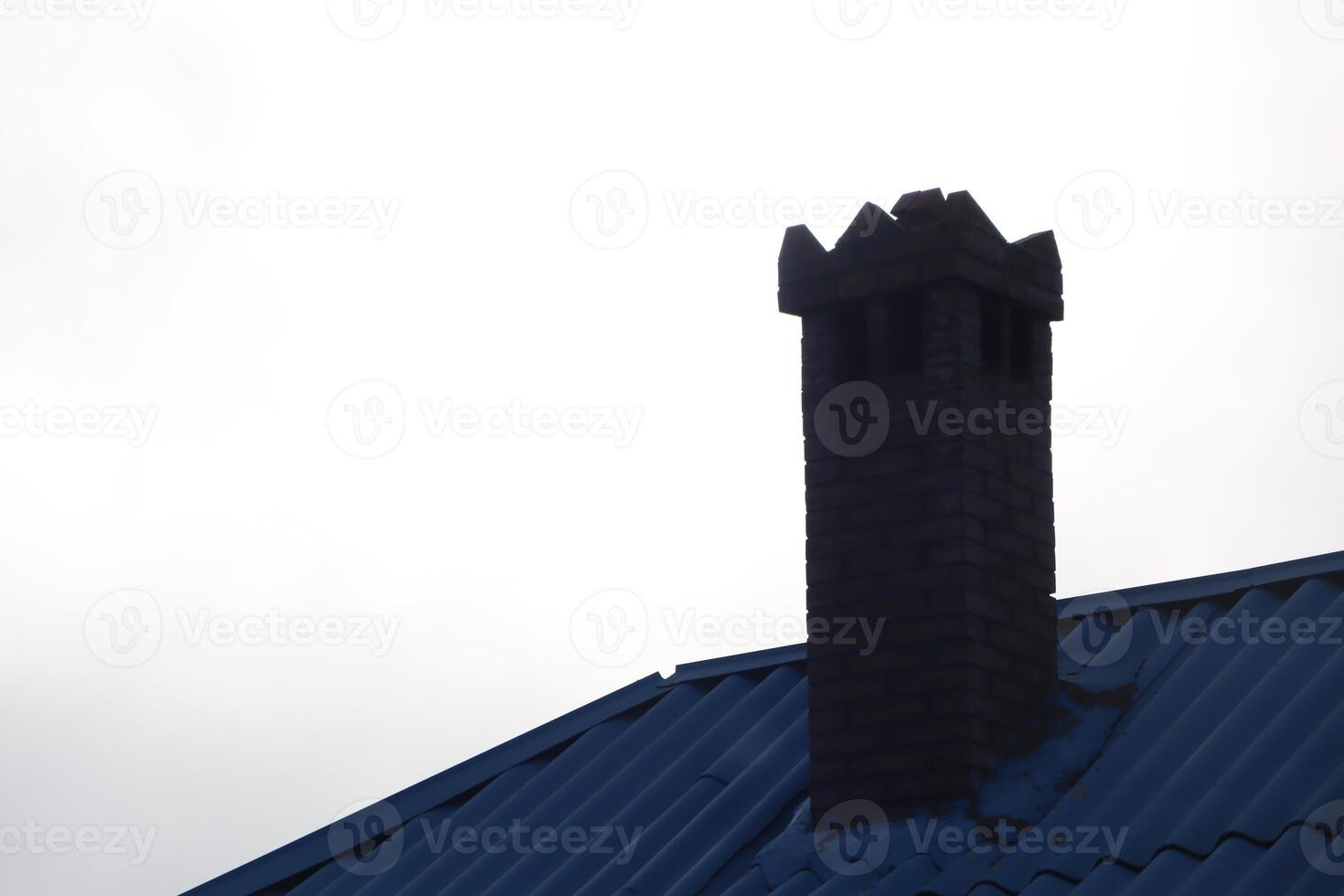 Charming Brick Chimney on Beautiful Blue Roof set Against a Dramatic Gray Sky Background photo