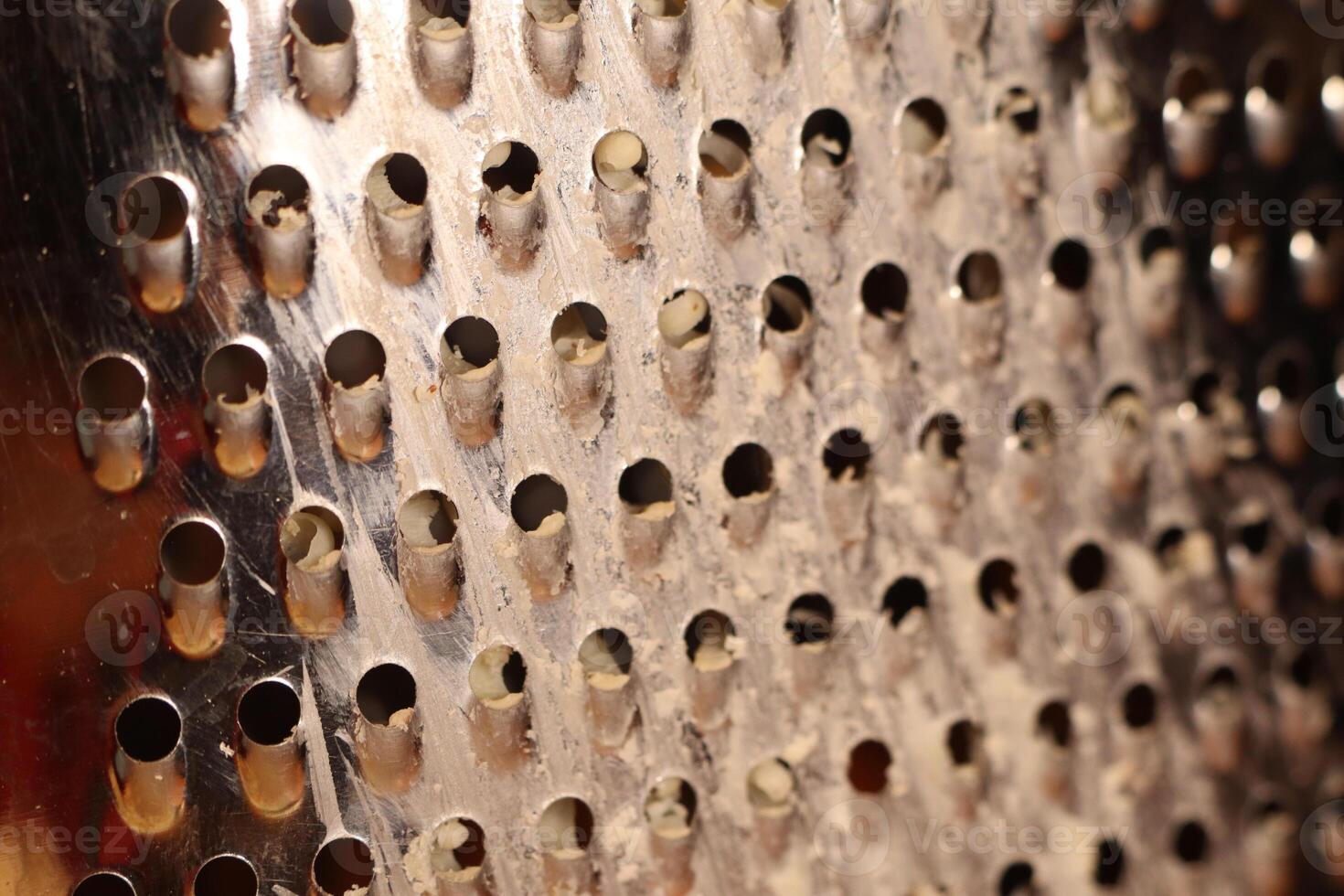 This is a CloseUp of a Grater Surface featuring multiple holes that serve a purpose photo