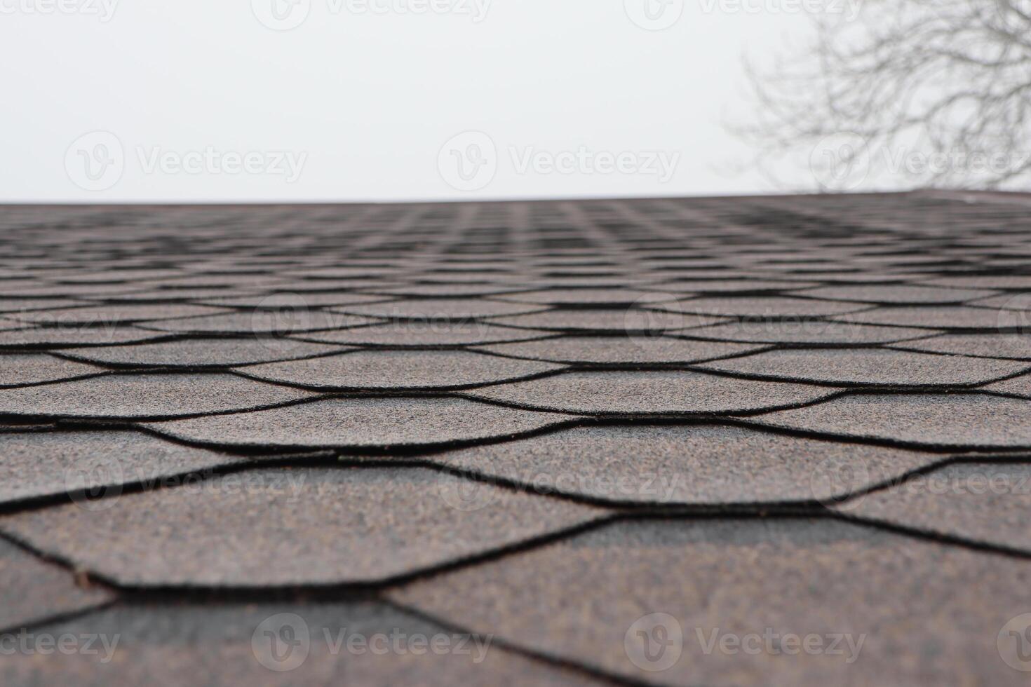 A CloseUp Image of Beautifully Textured Roof Shingles Set Against a Dramatic Cloudy Sky on This Day photo