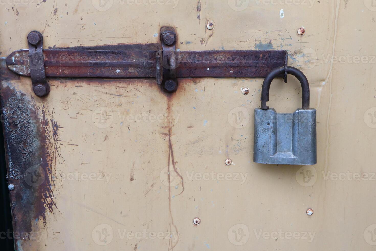 A Rusty Lock and Latch Attached to a Vintage Door, Highlighting Interesting Details and Design photo