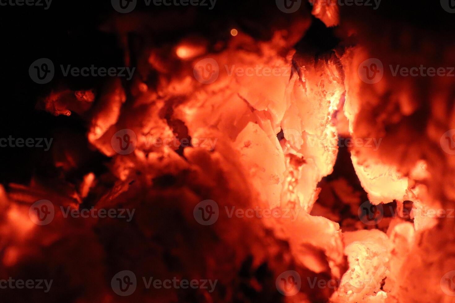 Glowing Ember Rocks Reside in a Dark Background That Highlights Their Beauty and Brightness photo