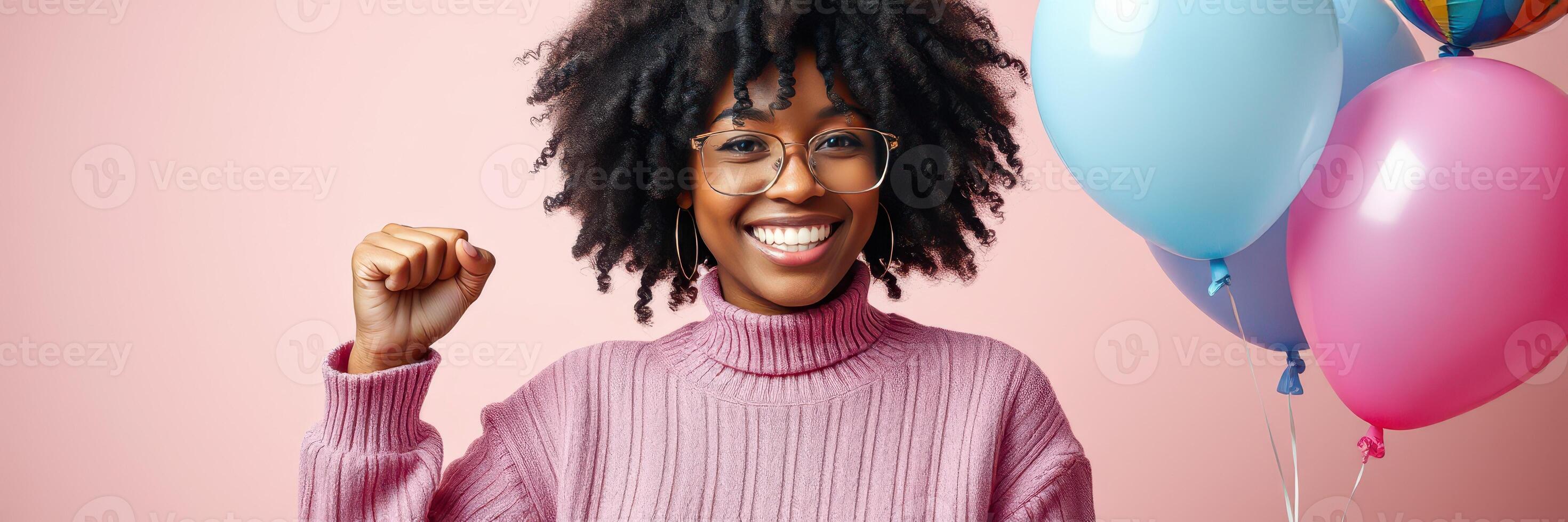 Young woman celebrating with colorful balloons and a joyful expression in a studio setting photo