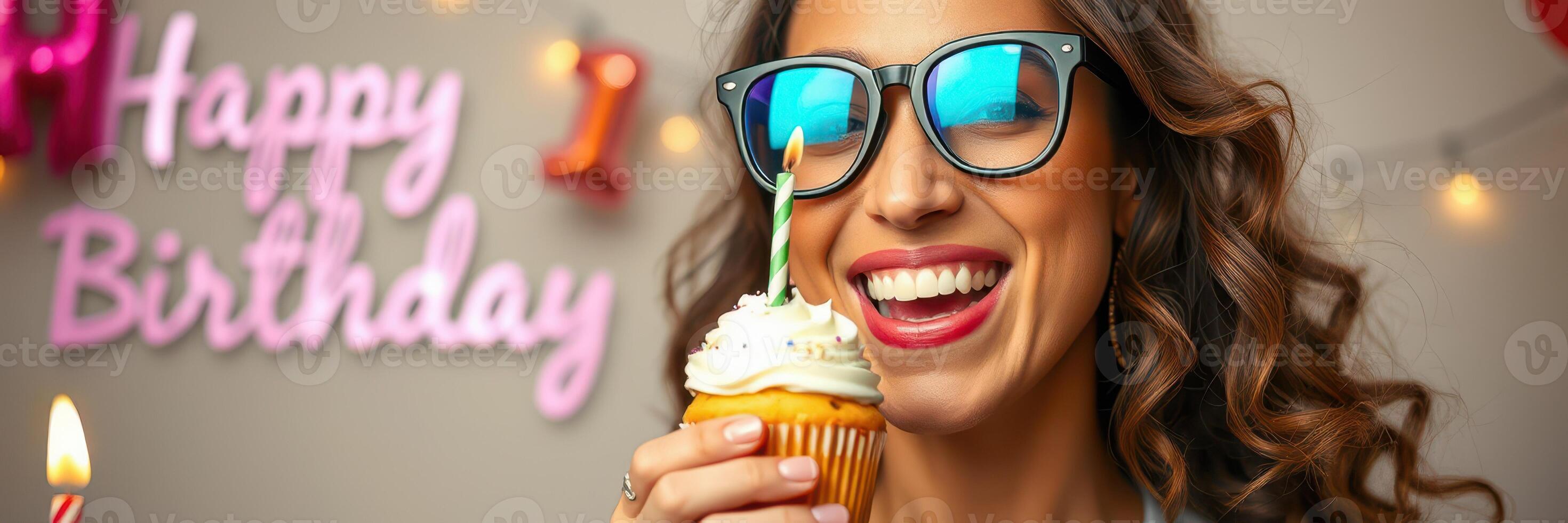 Joyful celebration with a smiling woman enjoying a cupcake during a birthday party in a decorated venue photo
