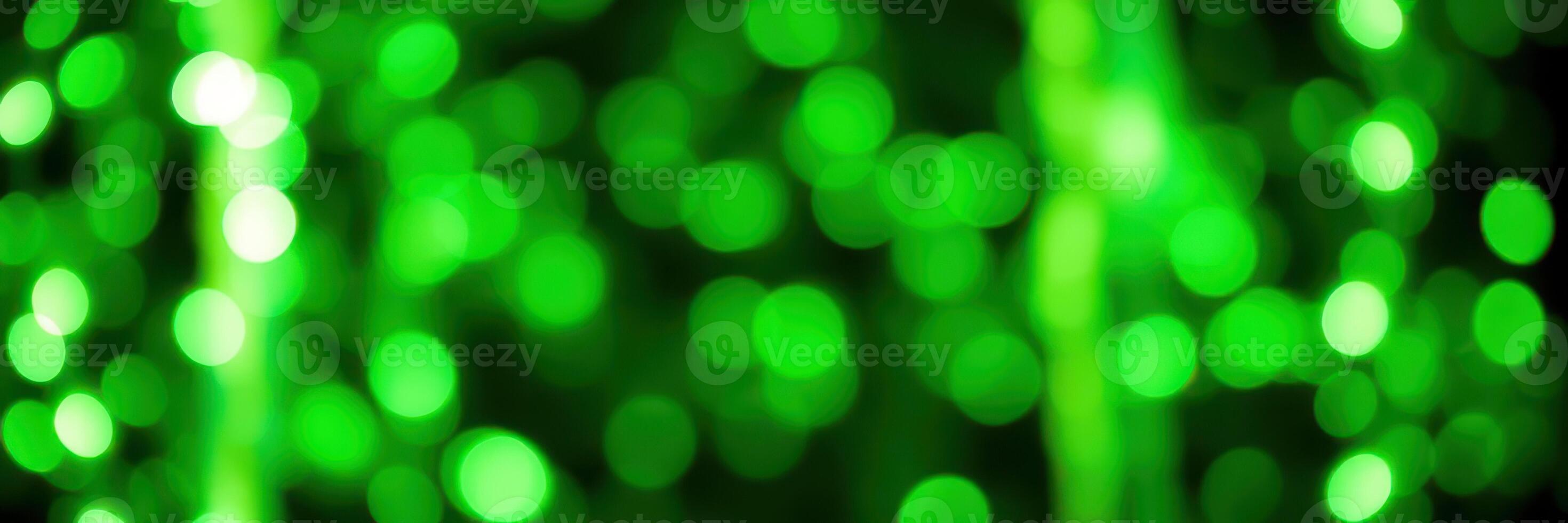 Shimmering green bokeh lights create a vibrant background for various celebrations and events photo