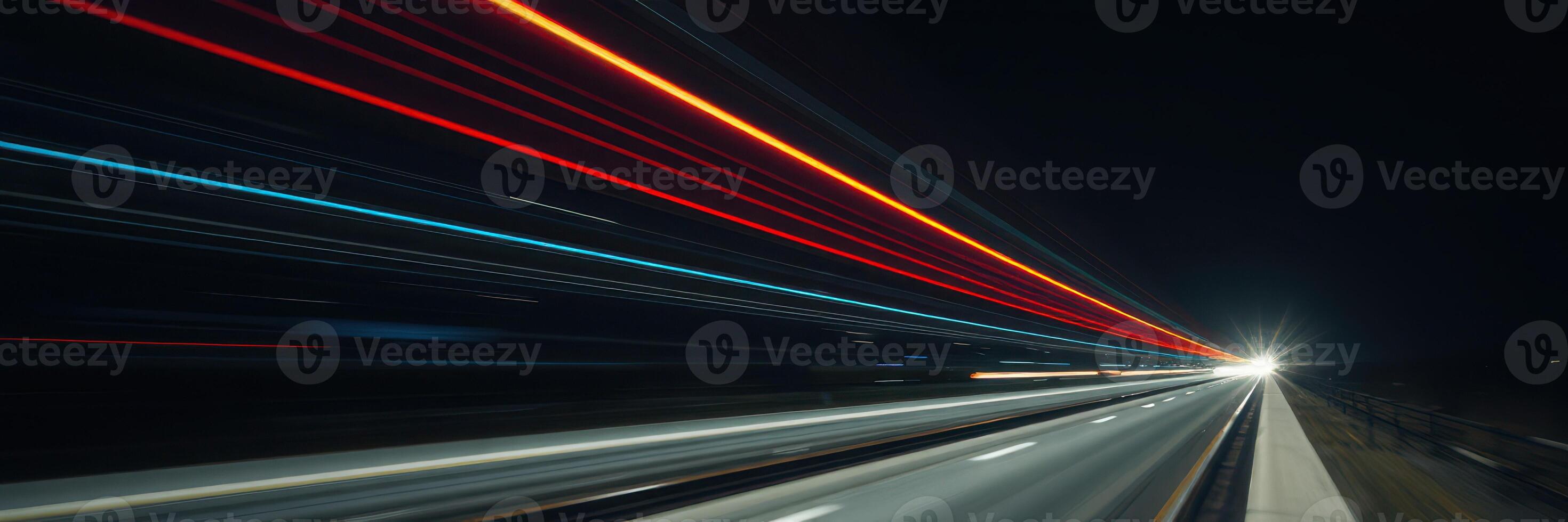 Nighttime highway lights create dynamic streaks of color in a long exposure shot, showcasing fast-moving vehicles along the road photo