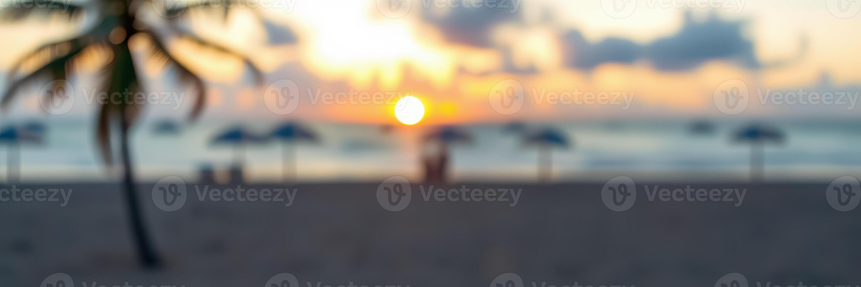 Sunset over the beach with silhouettes of palm trees and people enjoying the view in the background photo