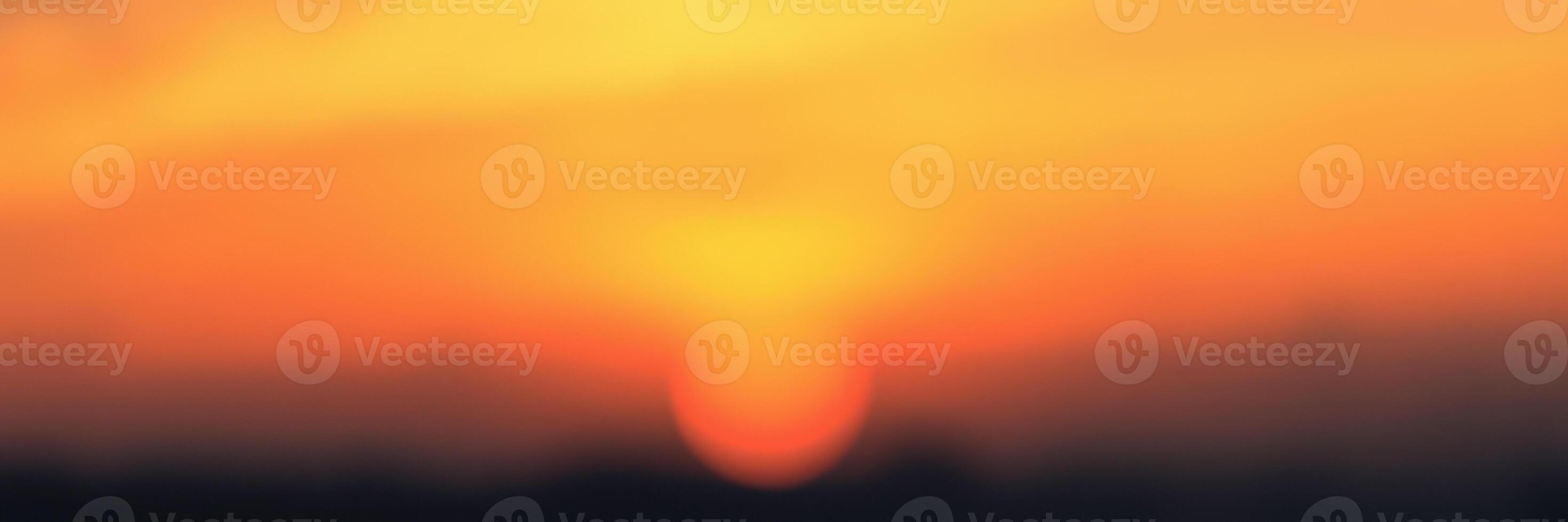 Sunset over the horizon creating a beautiful blend of orange and yellow colors in the evening sky photo