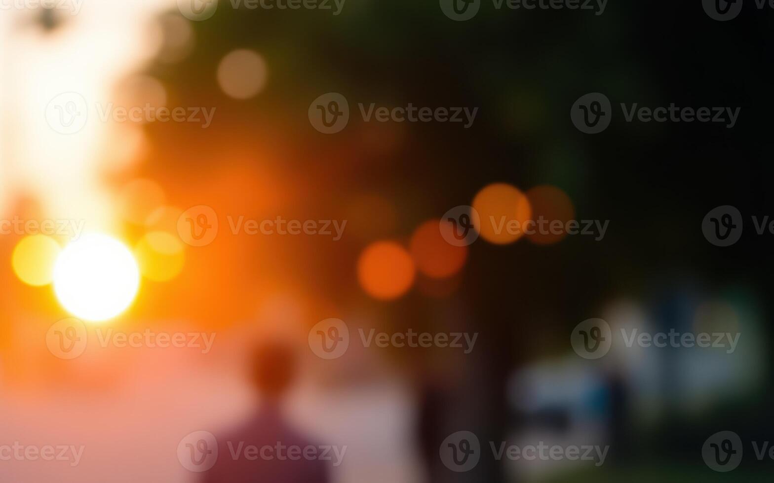 Golden sunset light creates a warm atmosphere as people walk along a tree-lined street in the evening photo