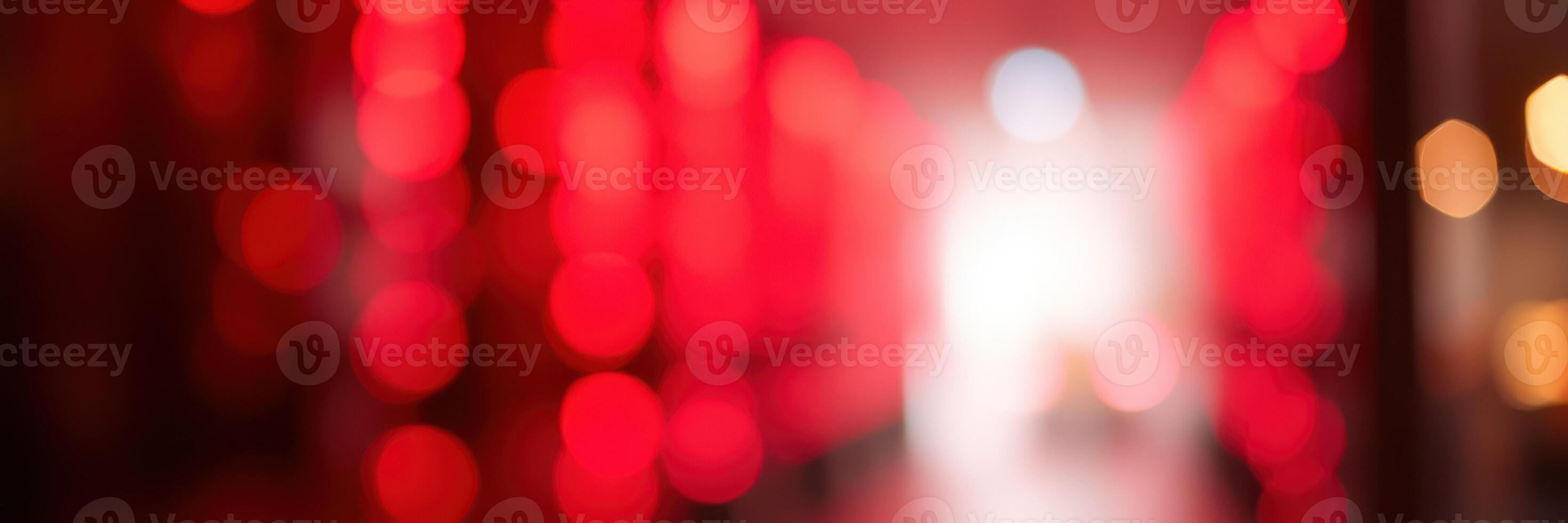 Vibrant red bokeh lights create a dreamy atmosphere in a lively urban setting during evening hours photo