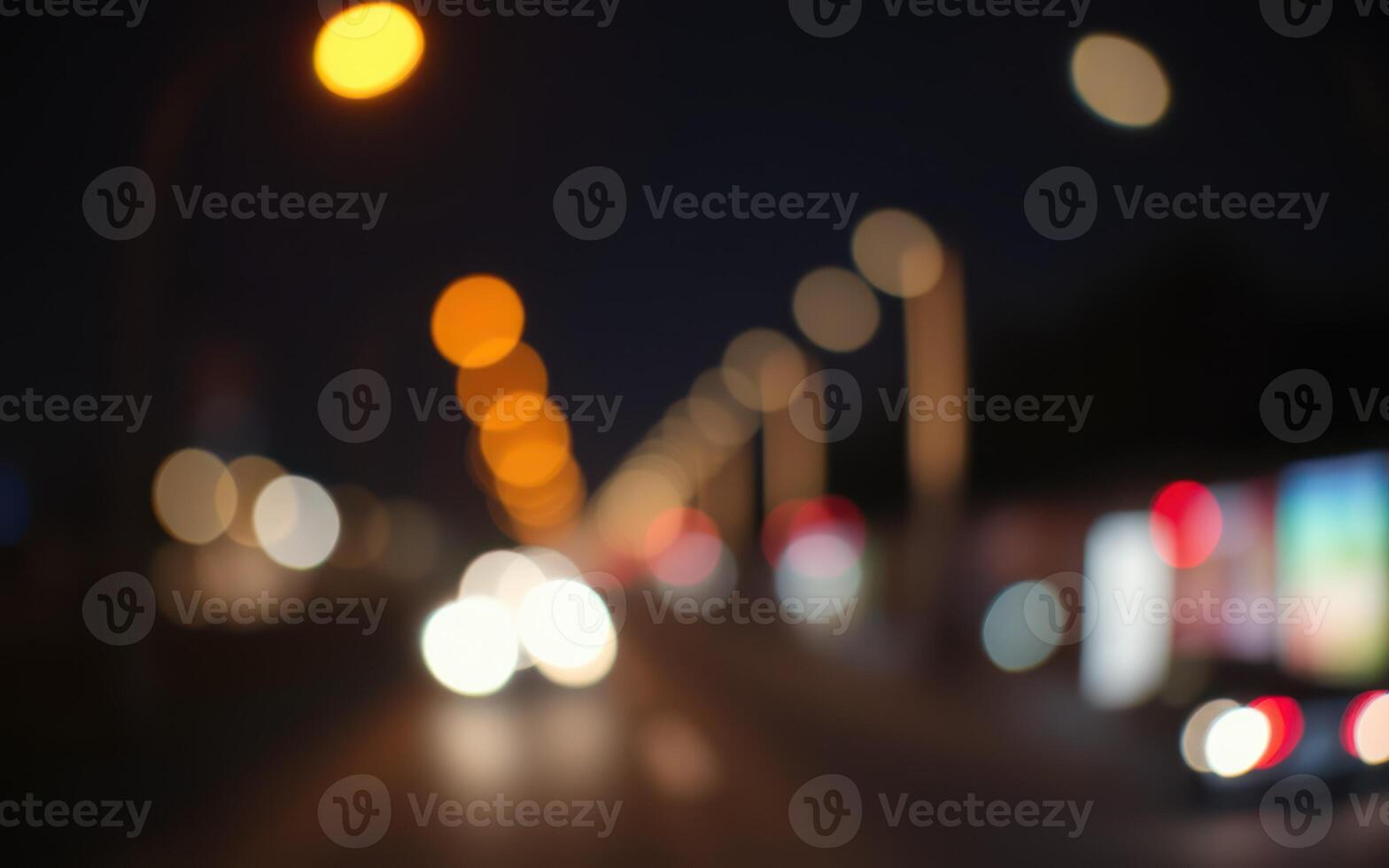 Nighttime urban street filled with blurred lights and car motion in a bustling city environment photo