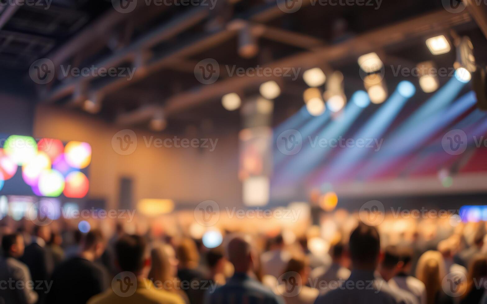 Large crowd at a lively event with colorful lights and a vibrant atmosphere in an indoor venue during the evening photo