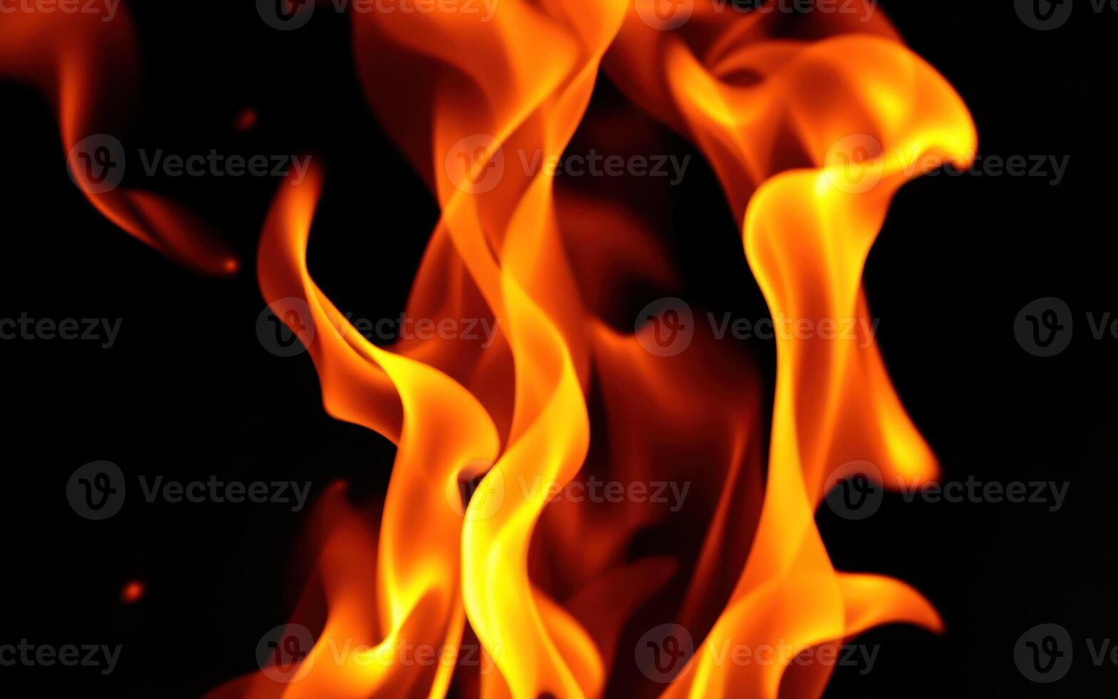 Vibrant orange flames dancing in darkness illuminate a warm glow photo