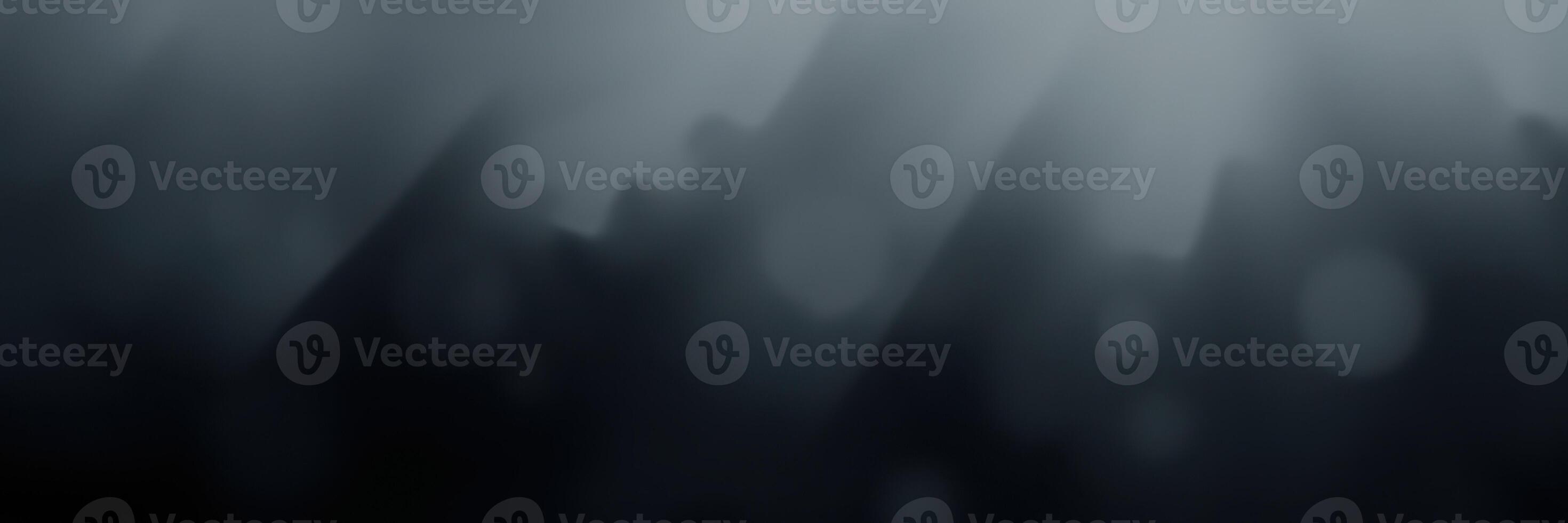 Mysterious fog envelops mountain landscape during early morning hours creating an eerie atmosphere photo